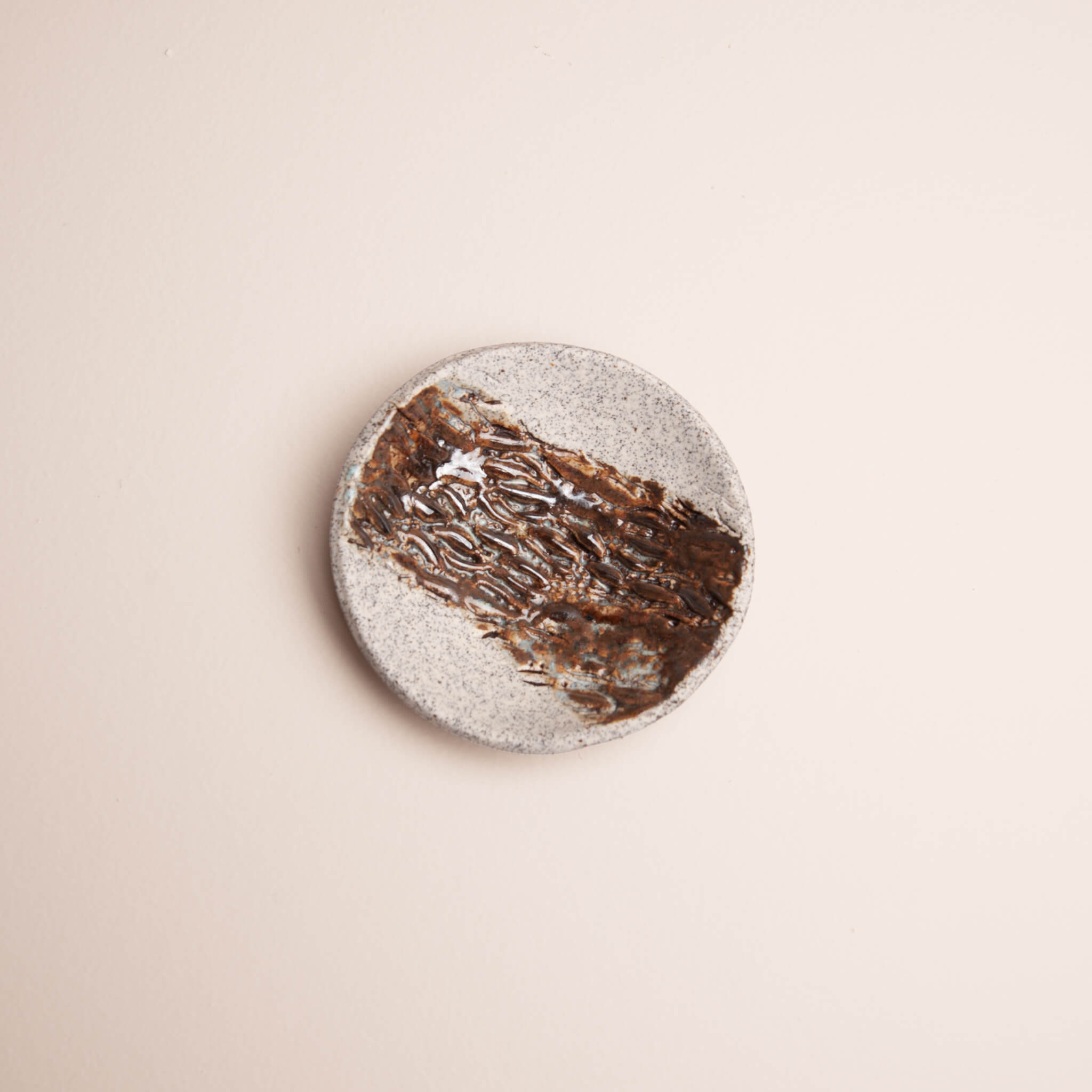 Overhead view of handmade ceramic Banksia Pod ring dish with rich brown glaze and ice blue accents on dragon fruit clay, by Jester Swink