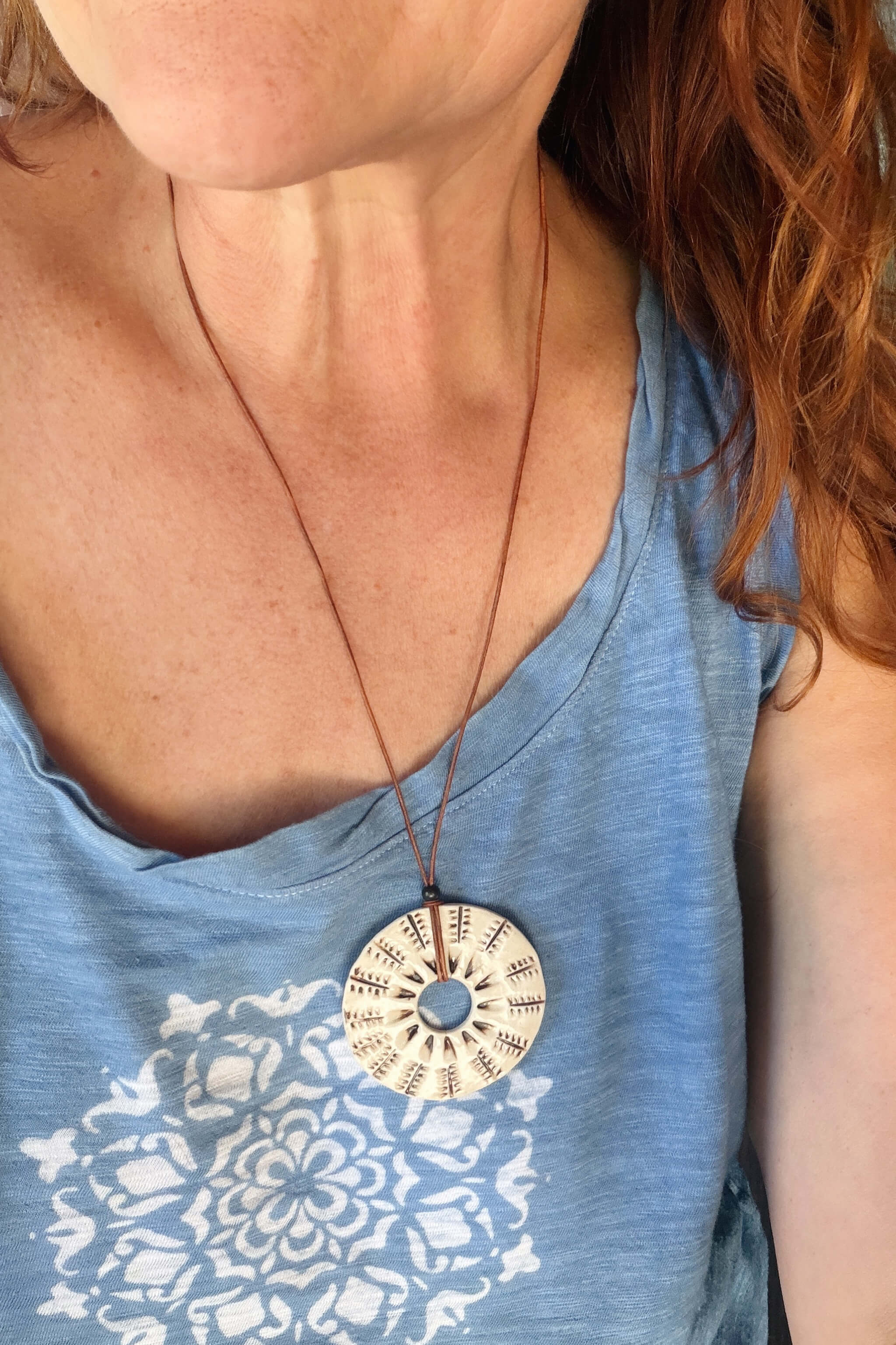 Handmade ceramic botanical sunburst pendant necklace worn at long boho length on caramel Italian leather — From the Fire FTF_0726 by Jester Swink
