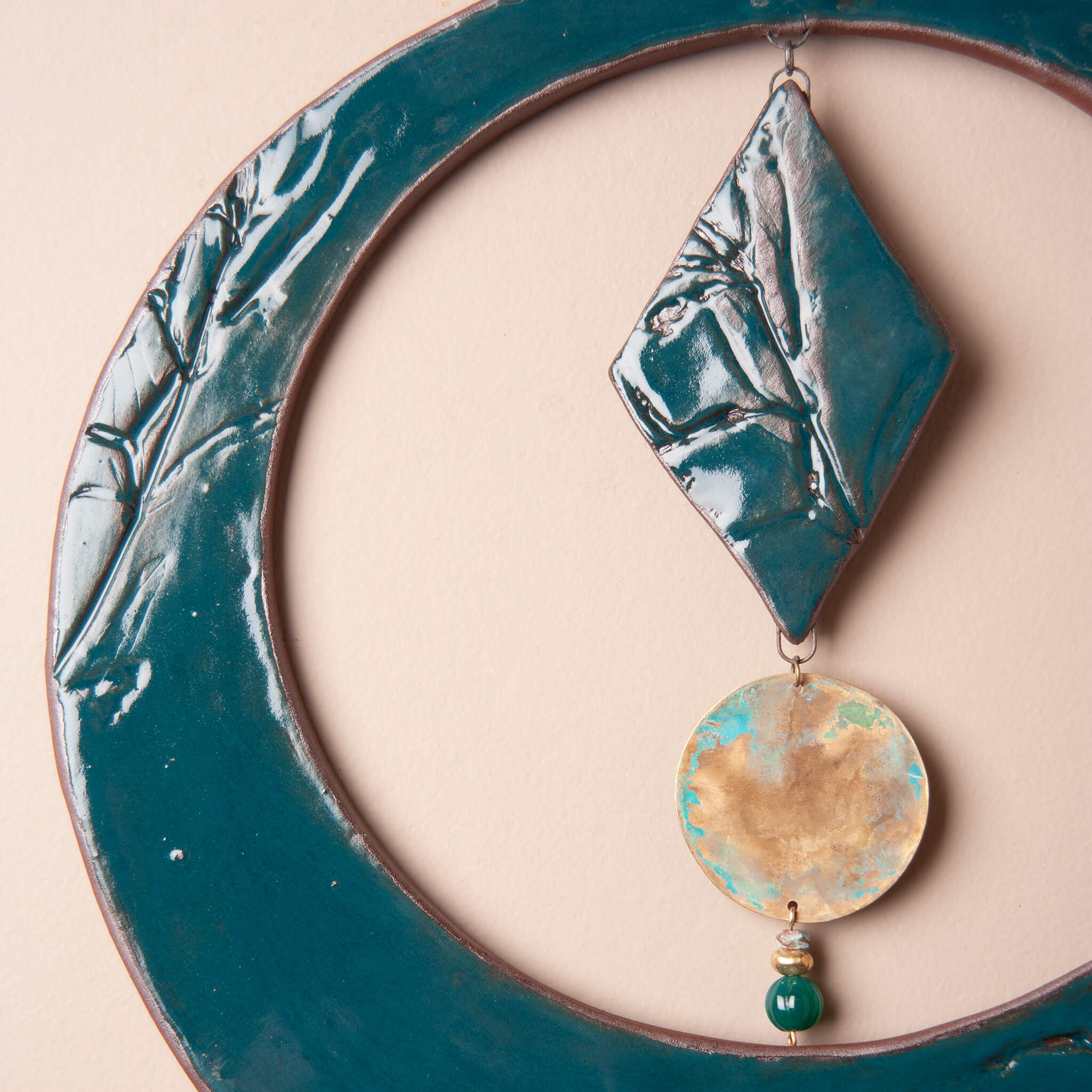 Detail of monkey flower impression and deep sea glaze on handmade ceramic wall hanging by Jester Swink, Santa Cruz Mountains California