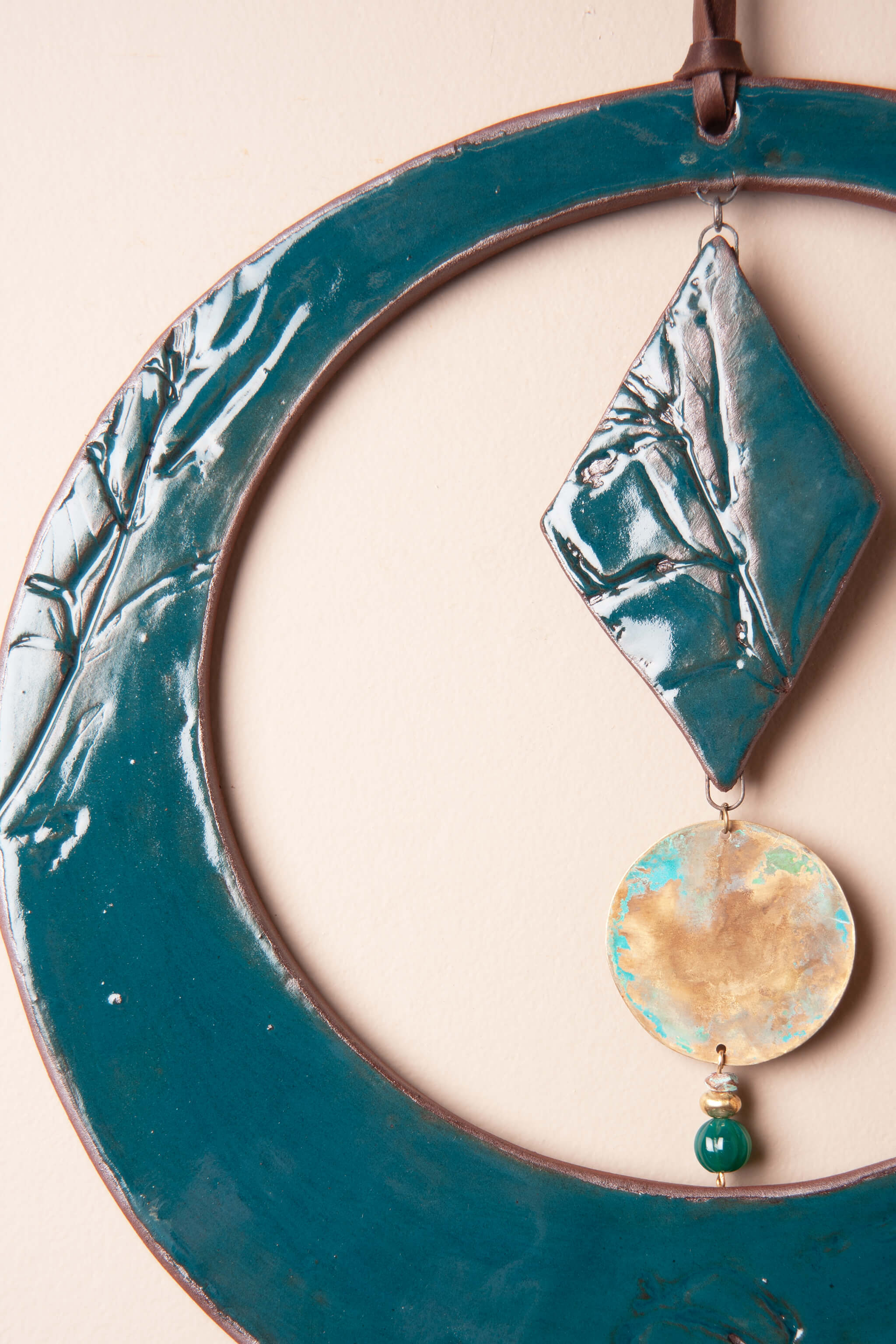 Detail of wildflower impressions and deep teal glaze on handmade ceramic wall hanging by Jester Swink — From the Fire FTF_0726