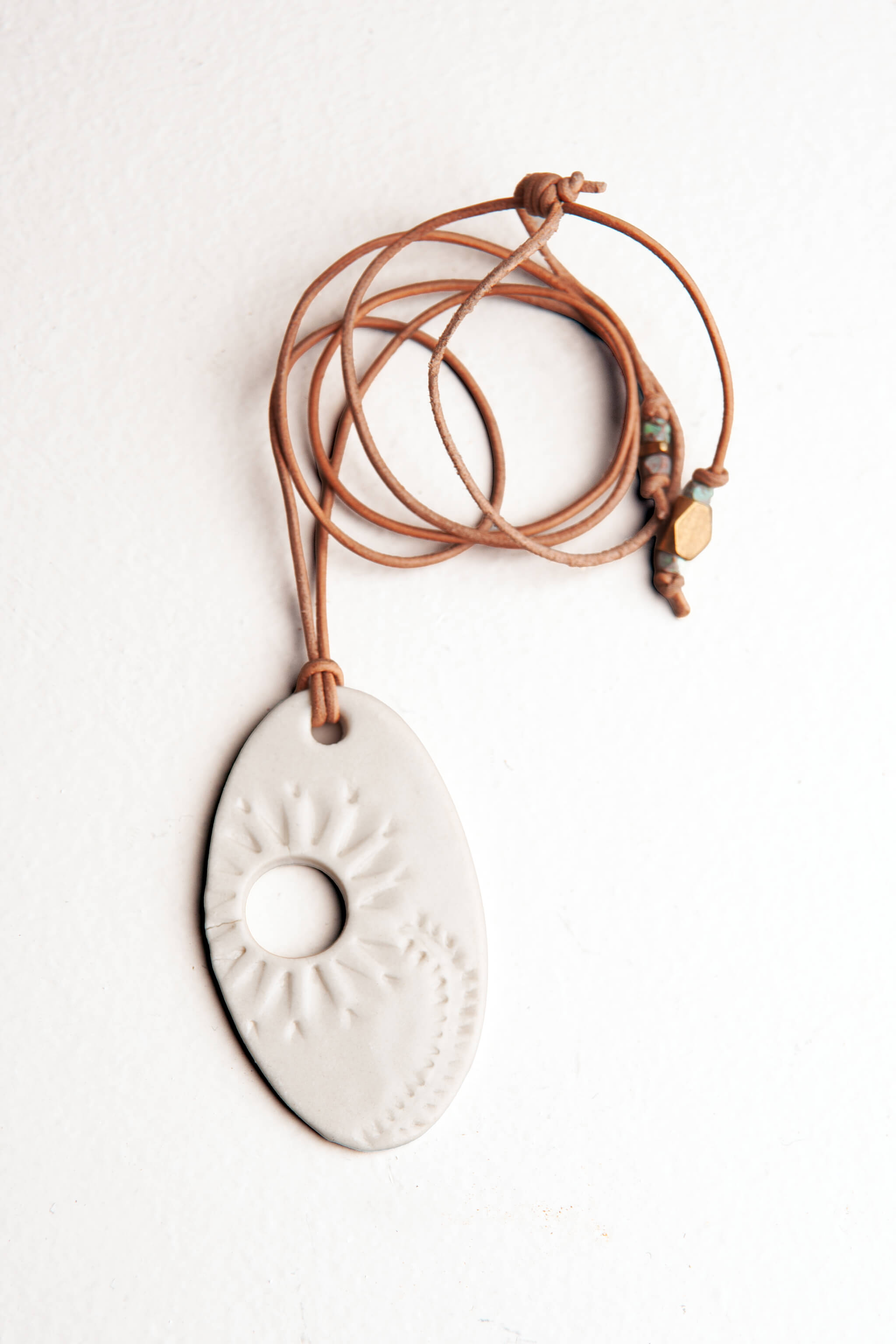 Handmade white porcelain floral ceramic pendant necklace with flower impression on adjustable camel Italian leather, kiln fired by Jester Swink Santa Cruz Mountains — From the Fire FTF_0726