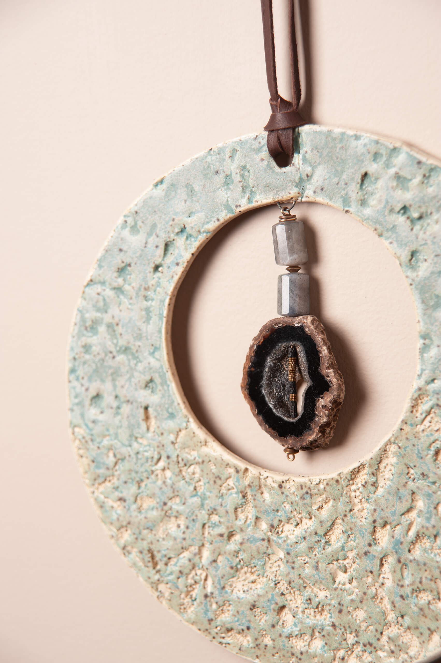 Close up of abalone and coral texture impression in seafoam glazed ceramic clay with druzy Botswana agate and labradorite beads