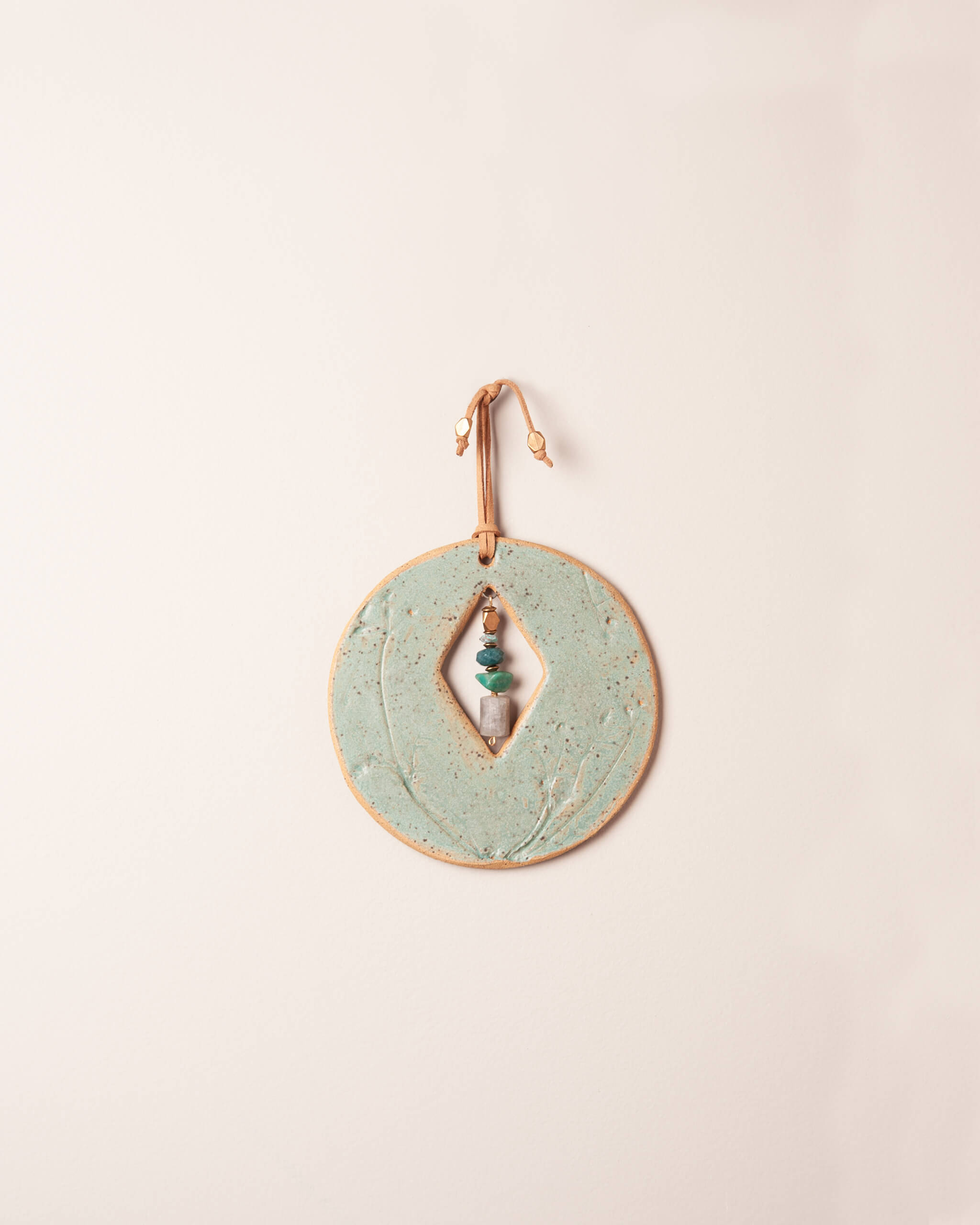 Cairn Diamond Moon handmade ceramic wall hanging with diamond center opening, wildflower impression and seafoam green glaze, made in the Santa Cruz Mountains of California