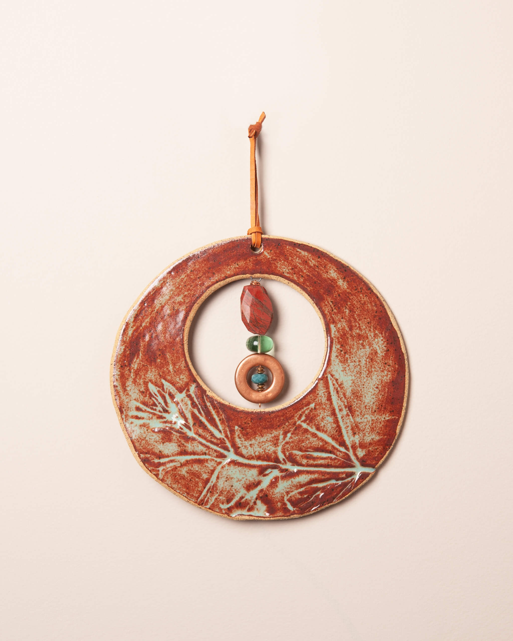 Ember Moon handmade ceramic wall hanging with wildflower impression, rusty orange and sage glaze, made in the Santa Cruz Mountains of California