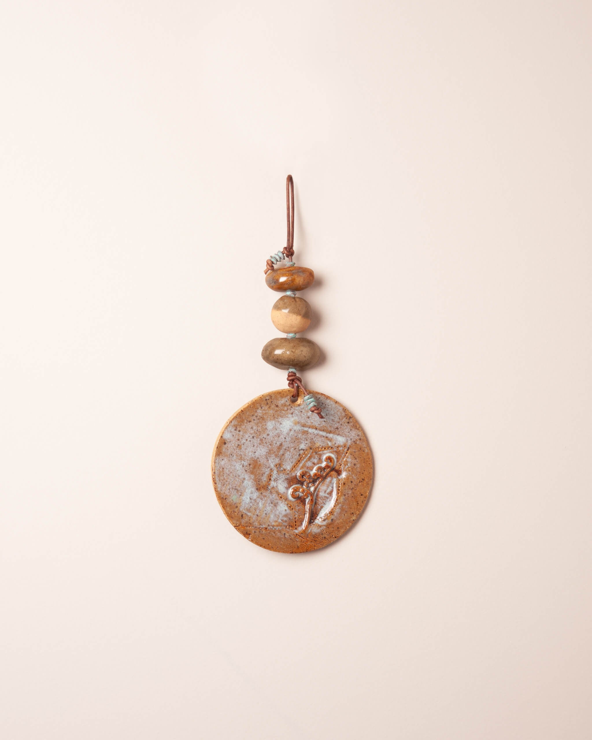 Fiddlehead Mist Stack handmade ceramic wall hanging with river rock forms, raised fiddlehead fern impression and sandy ice blue glaze, made in the Santa Cruz Mountains of California