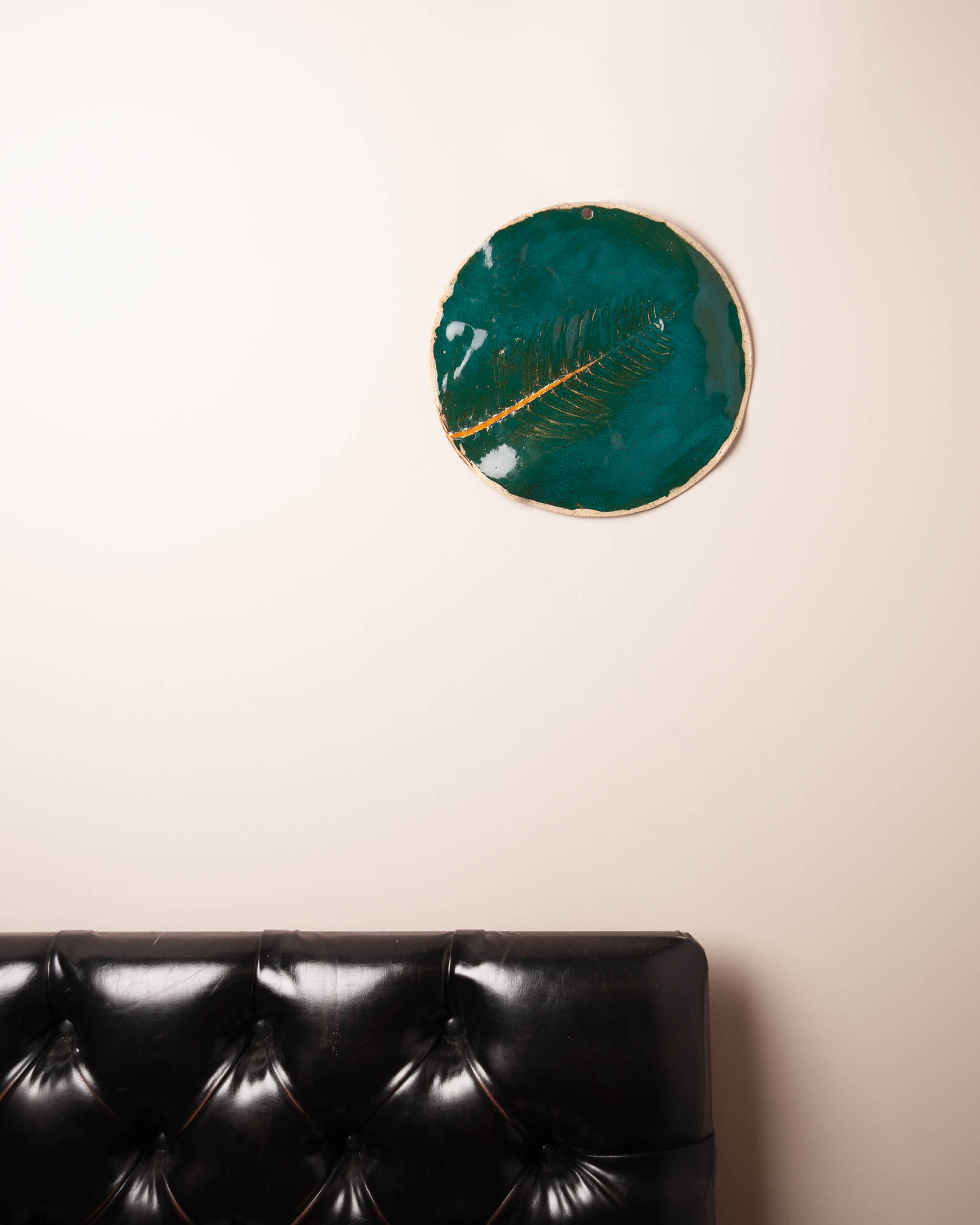 Golden Fern handmade ceramic wall plaque displayed on wall showing full emerald glaze and gold kintsugi crack detail