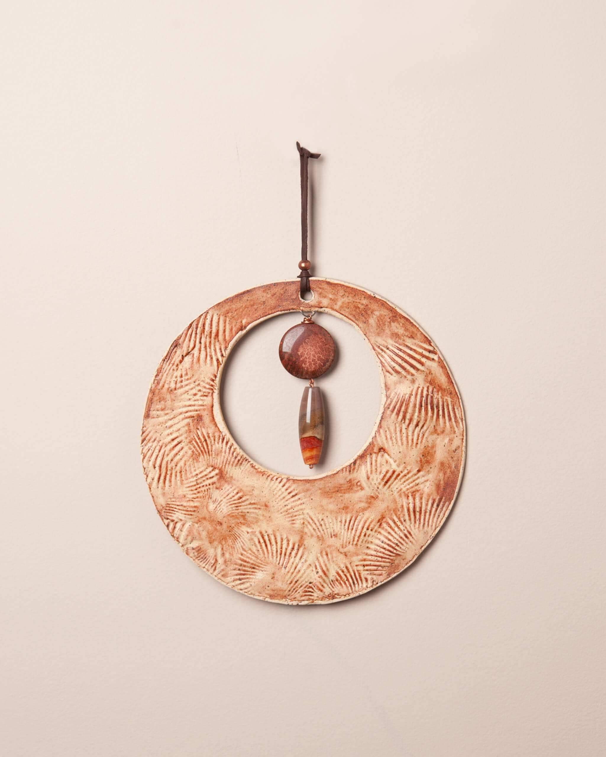 Shore Moon handmade ceramic wall hanging with shell impression and rusty orange glaze, made in the Santa Cruz Mountains of California