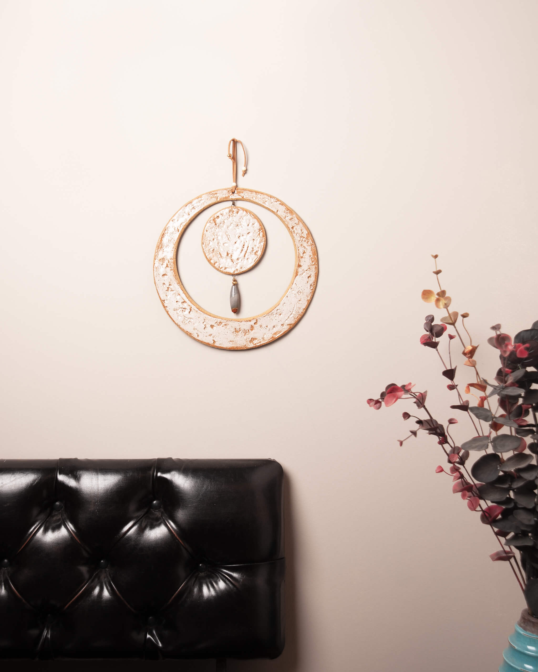 Solstice Moon large handmade ceramic wall art with ocean picture jasper and tan leather cord in natural home setting