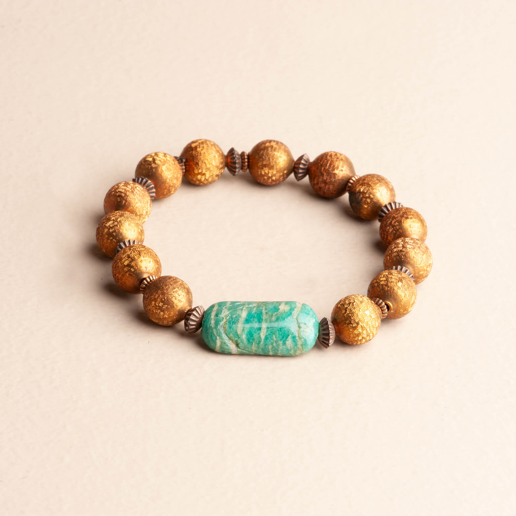 Handmade 7.5-inch stretch bracelet featuring a smooth, rectangular Amazonite stone in pale teal and textured bronze beaded accents.