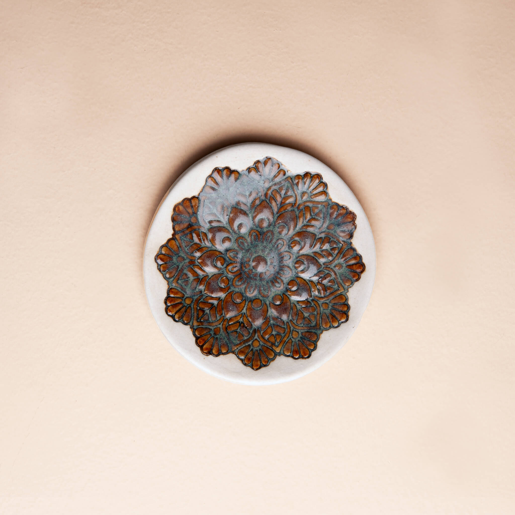 Handmade white clay ring dish with a highly textured mandala impression and deep blue Tiger's Eye glaze in the center.