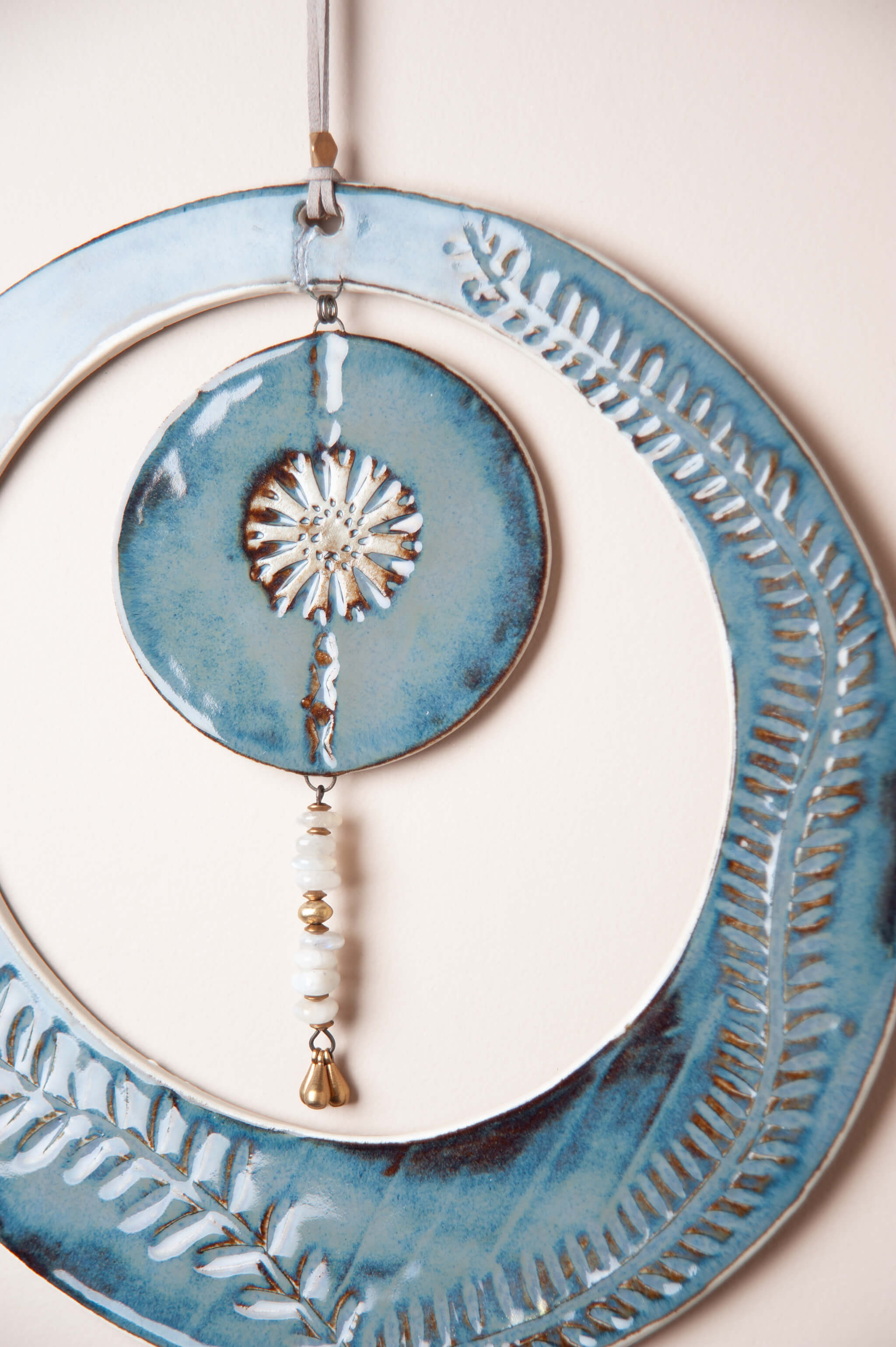 Detail of hand carved vine leaves and flower disc on large handmade ceramic wall art by Jester Swink, Santa Cruz Mountains California