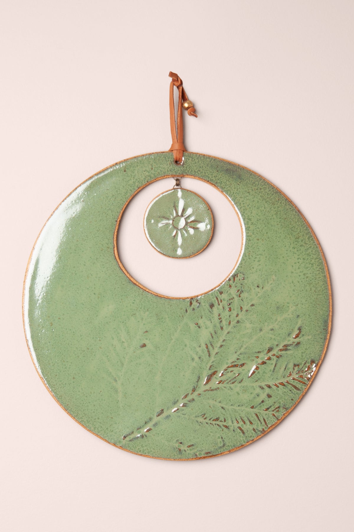 Large handmade circle ceramic wall hanging in Antique Aquamarine glaze with pressed redwood needle impressions and a sun at the center, kiln fired by Jester Swink Santa Cruz Mountains — From the Fire FTF_1026