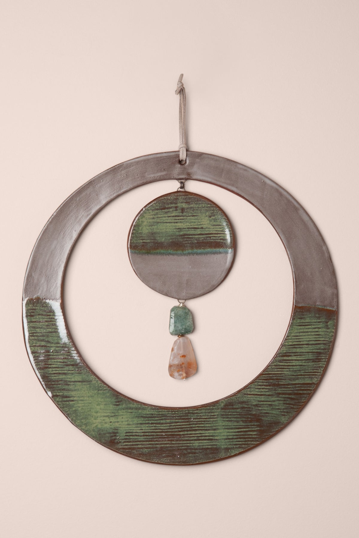 Large handmade circle ceramic wall hanging with modern stripes in green and soft purple glaze and a rutilated quartz and ocean jasper dangle, kiln fired by Jester Swink Santa Cruz Mountains — From the Fire FTF_1026