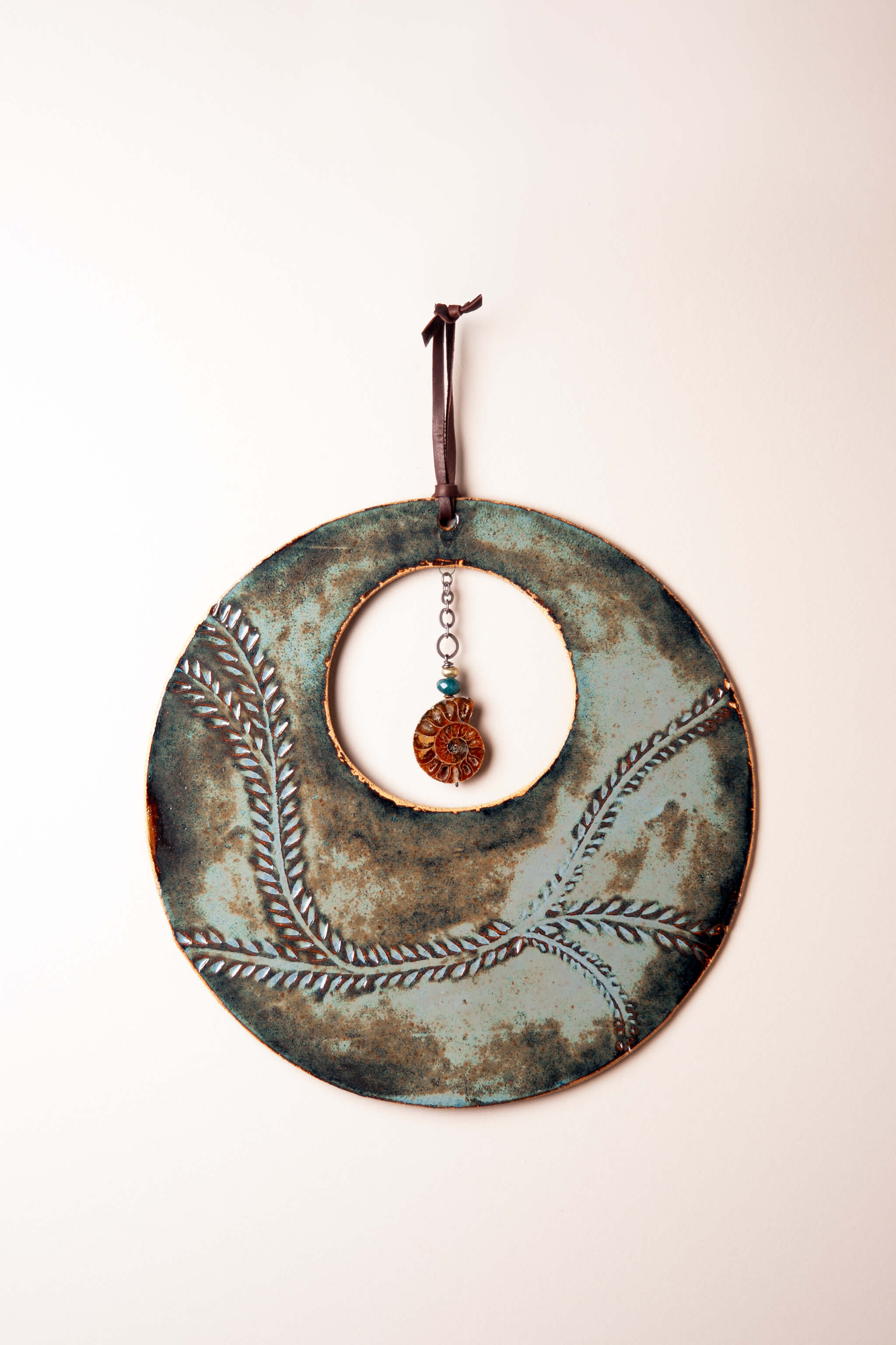 Large handmade circle ceramic wall hanging in aqua marine glaze with vine leaf pattern and ammonite fossil, kiln fired by Jester Swink Santa Cruz Mountains — From the Fire FTF_0726