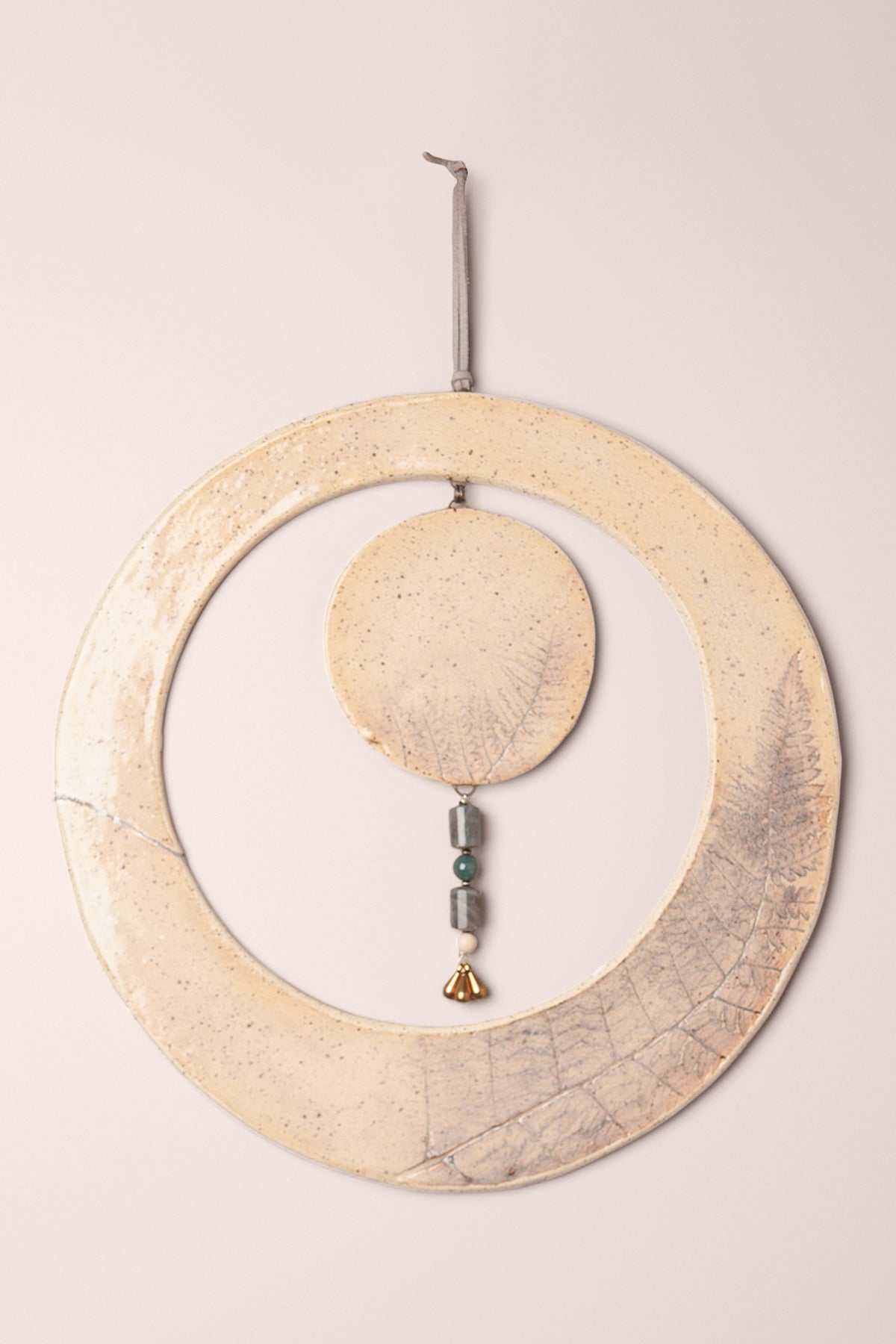 Large handmade circle ceramic wall hanging in clear glaze with fern impressions and a labradorite, aventurine and mountain jasper dangle, kiln fired by Jester Swink Santa Cruz Mountains — From the Fire FTF_1026