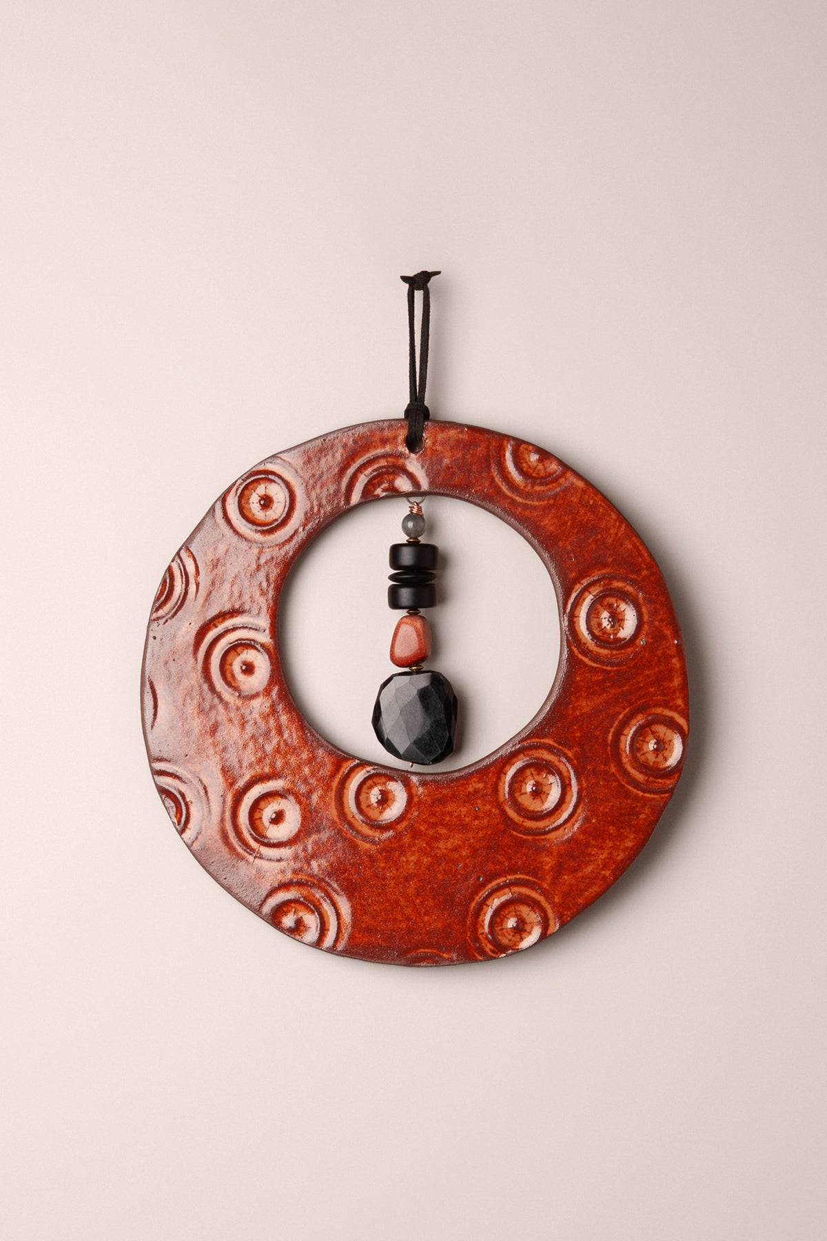 Large handmade circle ceramic wall hanging in Oolong glaze with pressed circles and a labradorite, onyx and goldstone dangle, kiln fired by Jester Swink Santa Cruz Mountains — From the Fire FTF_1026
