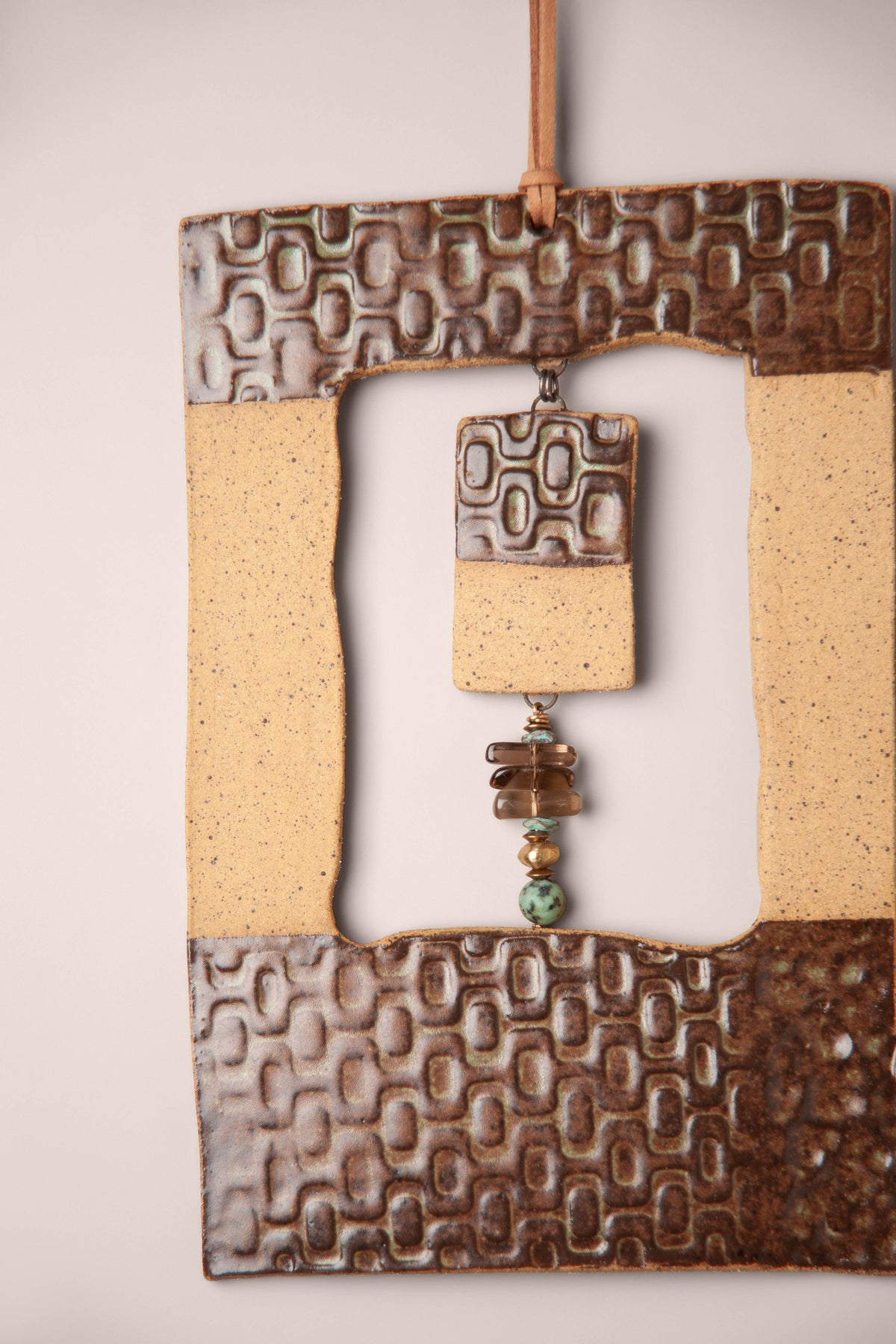 Detail of the pressed pattern and raw clay side on a large handmade rectangle ceramic wall hanging, kiln fired by Jester Swink, Santa Cruz Mountains California