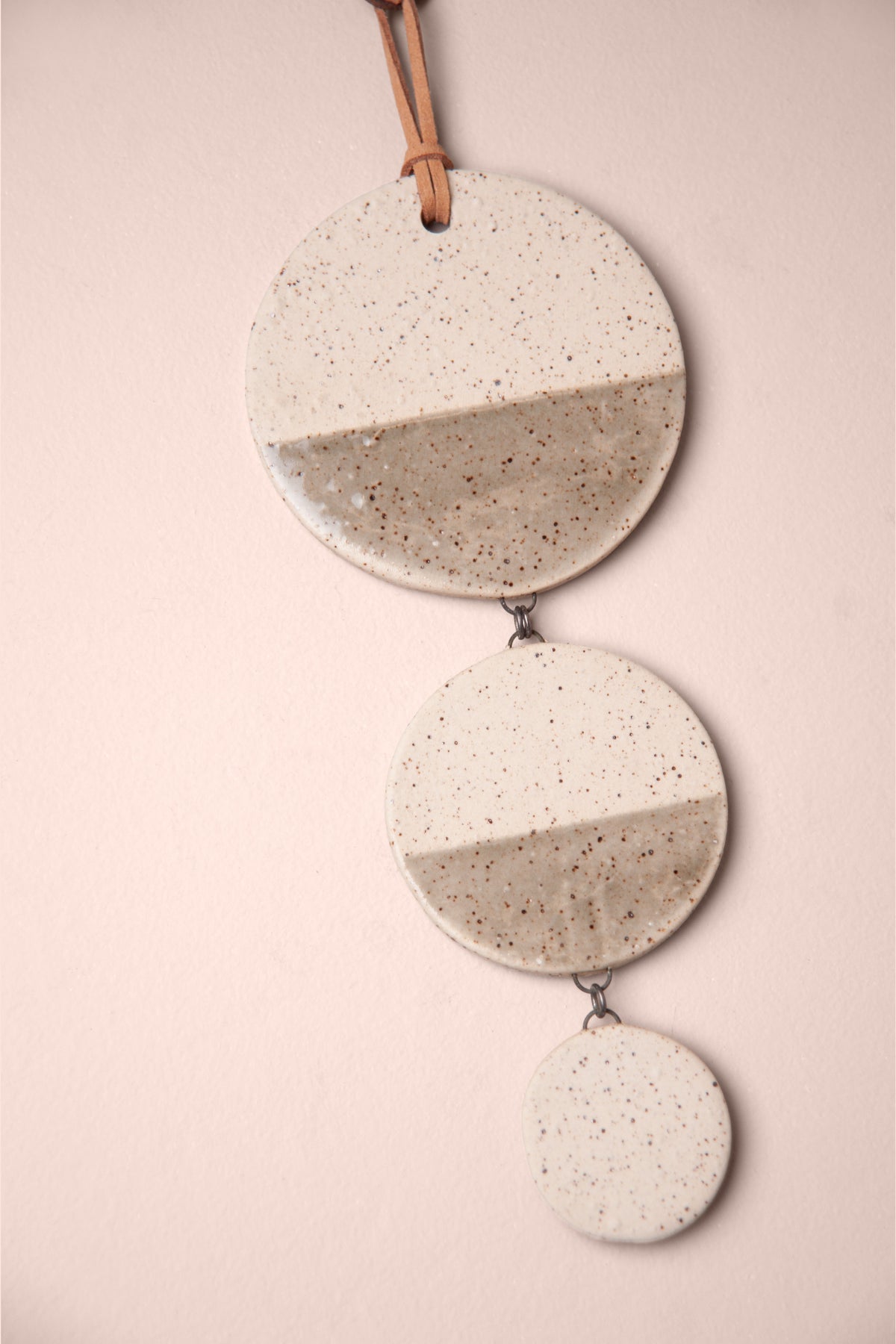 Detail of the smoke grey and speckled glaze on a large handmade tiered ceramic wall hanging, kiln fired by Jester Swink, Santa Cruz Mountains California