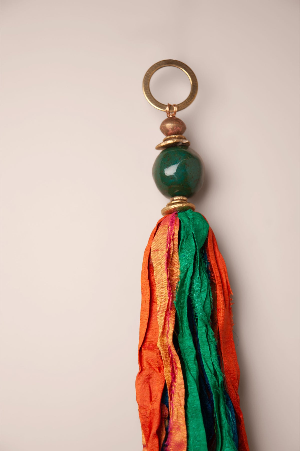 Detail of the raw silk tassel and emerald ceramic bead on a large handmade windcatcher, made by Jester Swink, Santa Cruz Mountains California