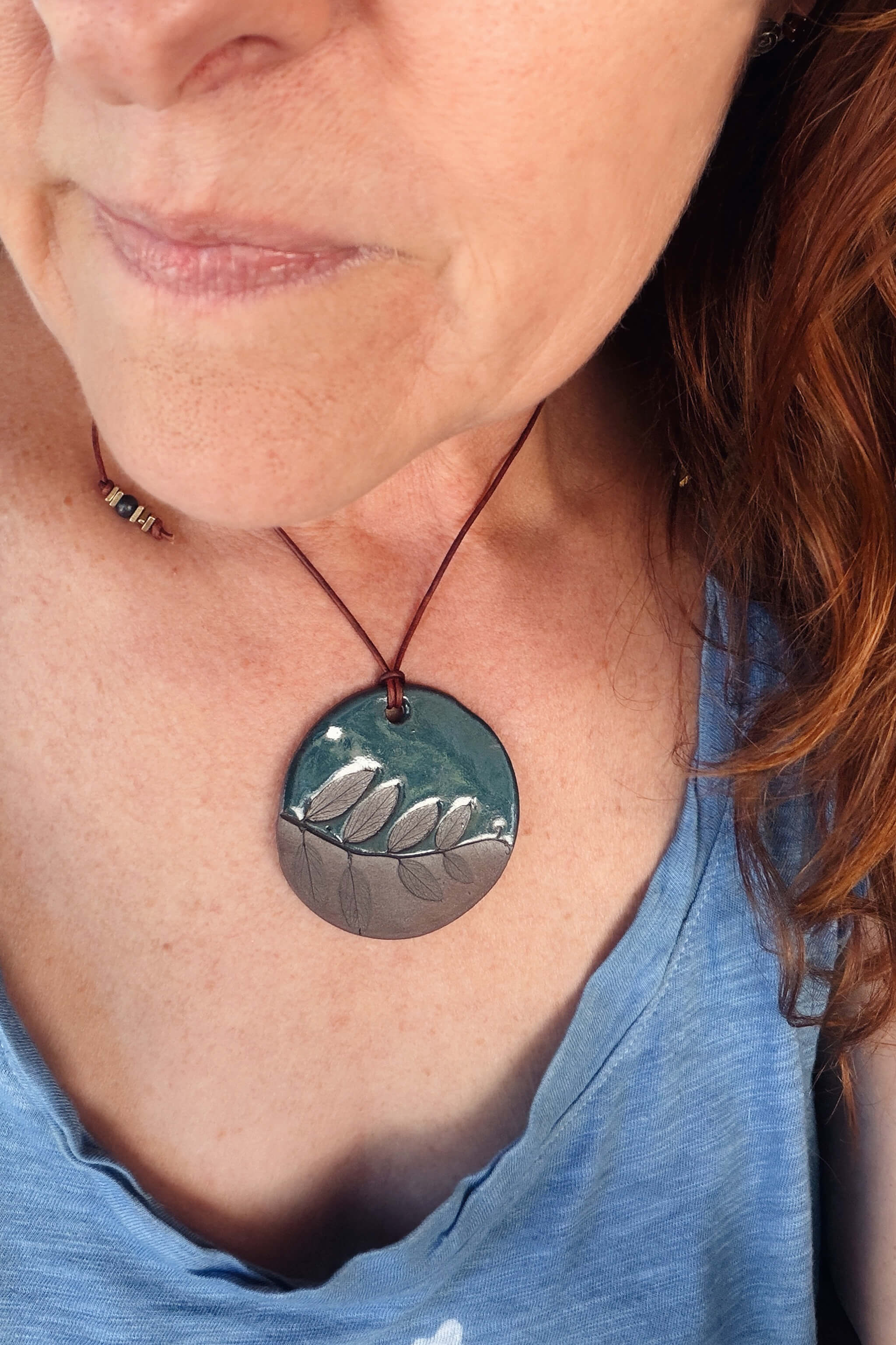 Handmade terracotta and deep sea blue ceramic leaf pendant necklace worn at shorter length — botanical statement ceramic jewelry From the Fire FTF_0726 by Jester Swink