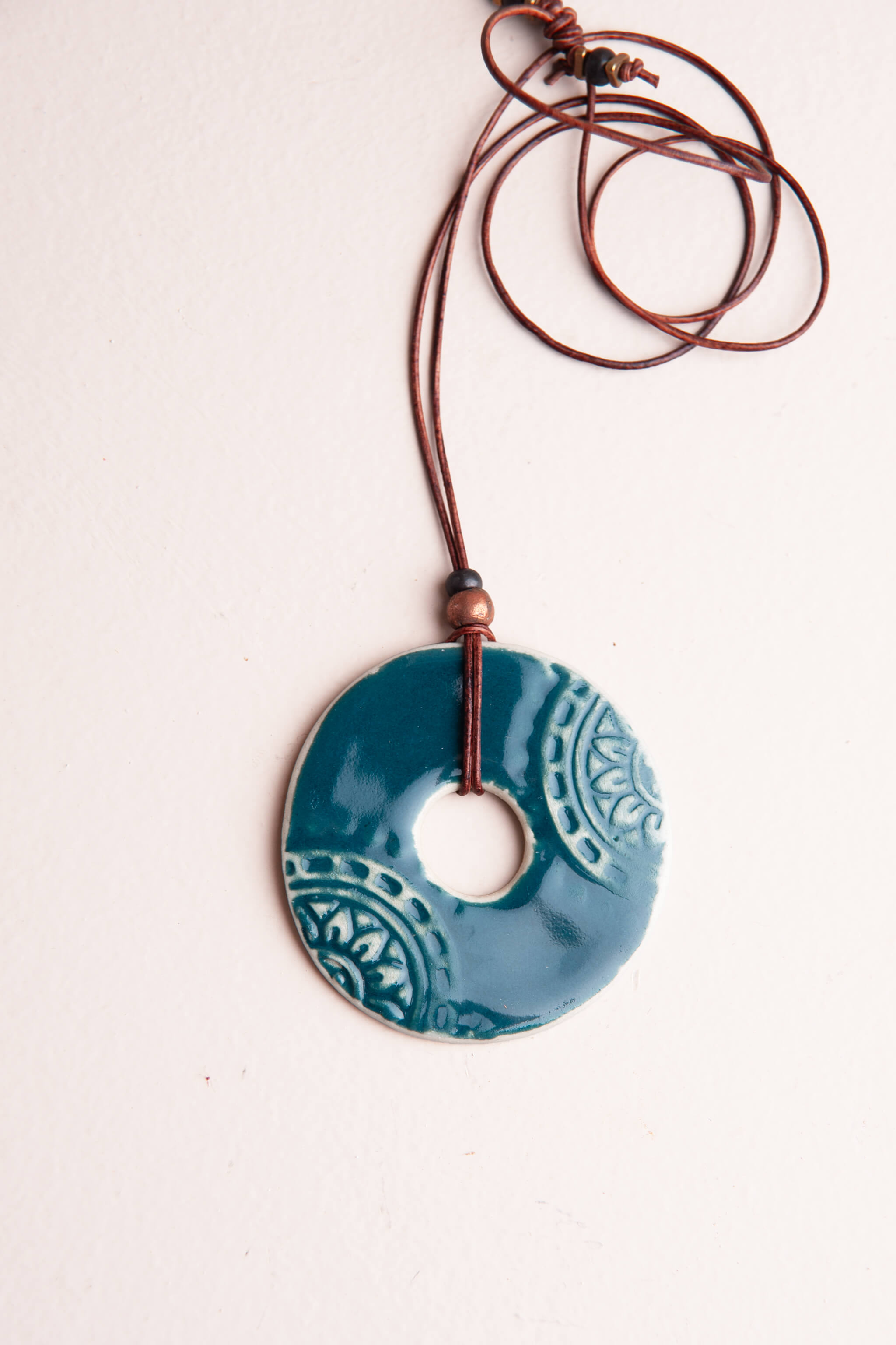 Handmade ceramic mandala pendant necklace in deep teal glaze on dark brown Italian leather, kiln fired by Jester Swink Santa Cruz Mountains — From the Fire FTF_0726