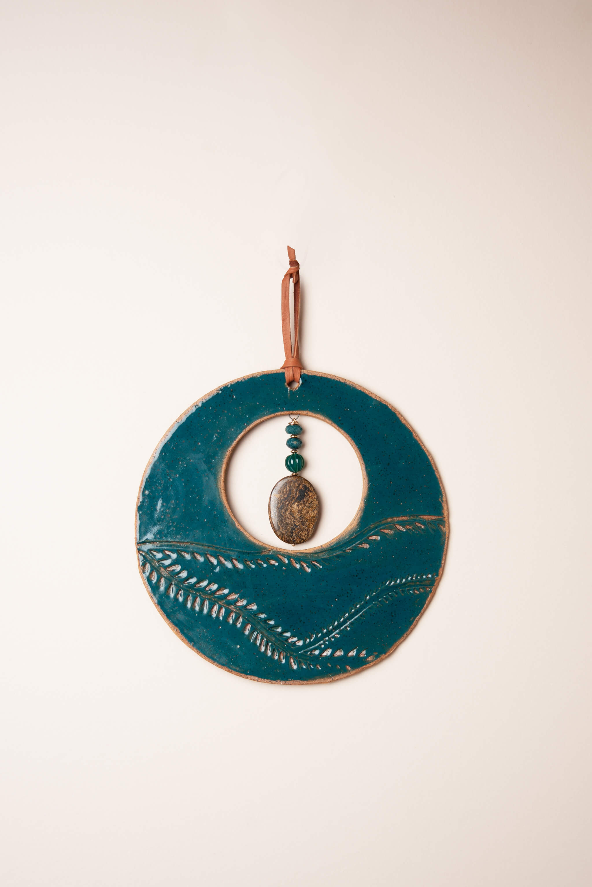 Medium handmade ceramic circle wall hanging in marine blue glaze with vine pattern, green onyx and bronzite, kiln fired by Jester Swink Santa Cruz Mountains — From the Fire FTF_0726