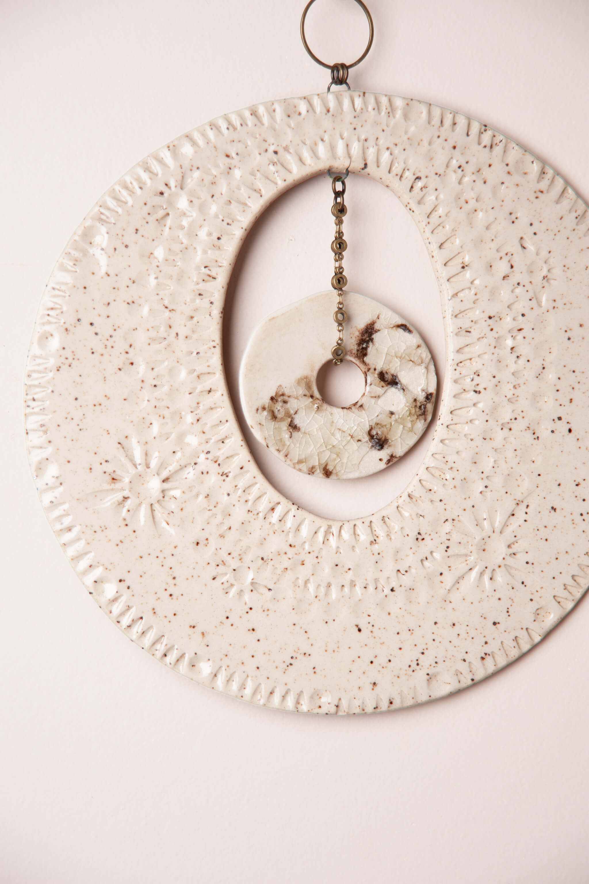 lose up of crackled porcelain pendant on brass chain suspended inside handmade ceramic natural wall hanging — modern coastal wall art by Jester Swink From the Fire FTF_0726