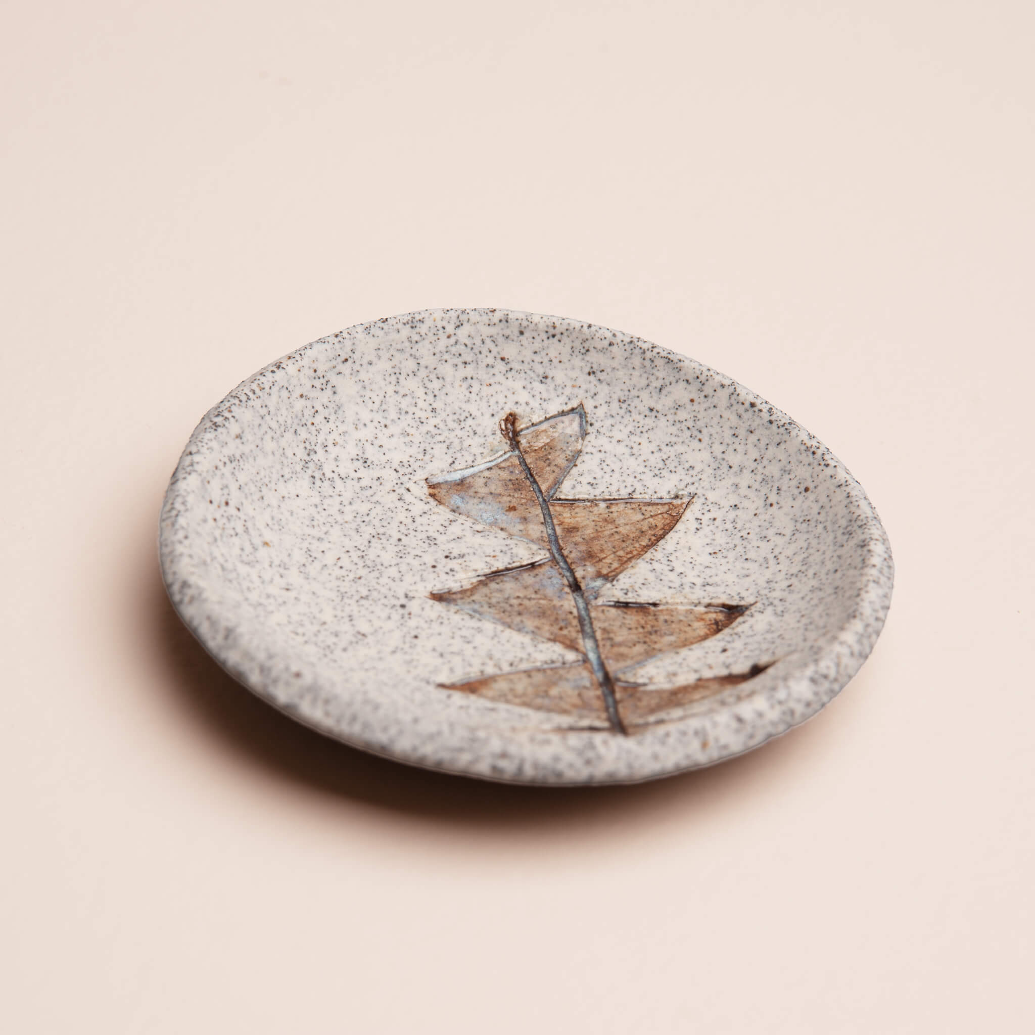 Angled view of handmade ceramic Protea Leaf ring dish showing depth and organic shape, brown glaze with blue tint, by Jester Swink