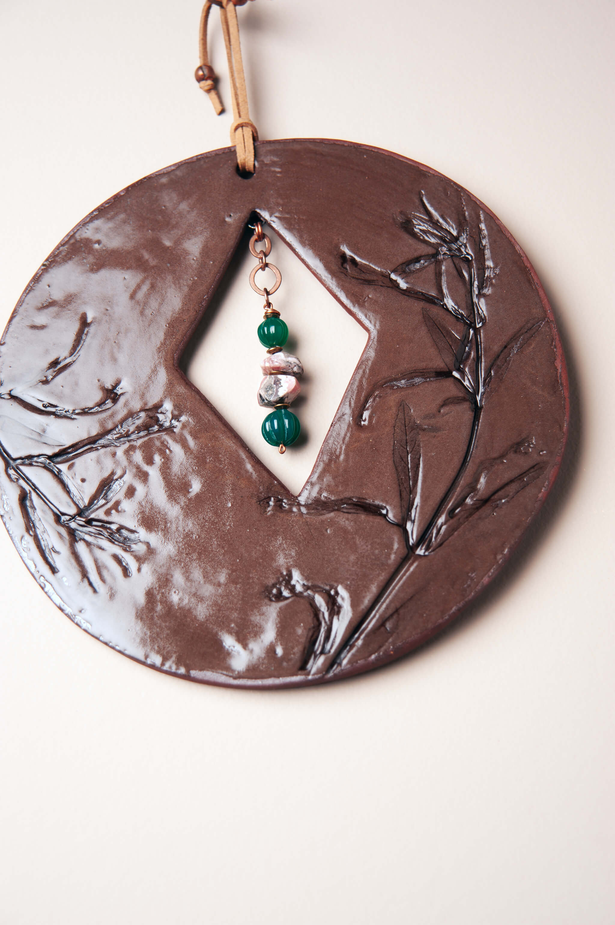 Green onyx and rhodochrosite suspended on copper chain inside small handmade ceramic wall art From the Fire FTF_0726 by Jester Swink