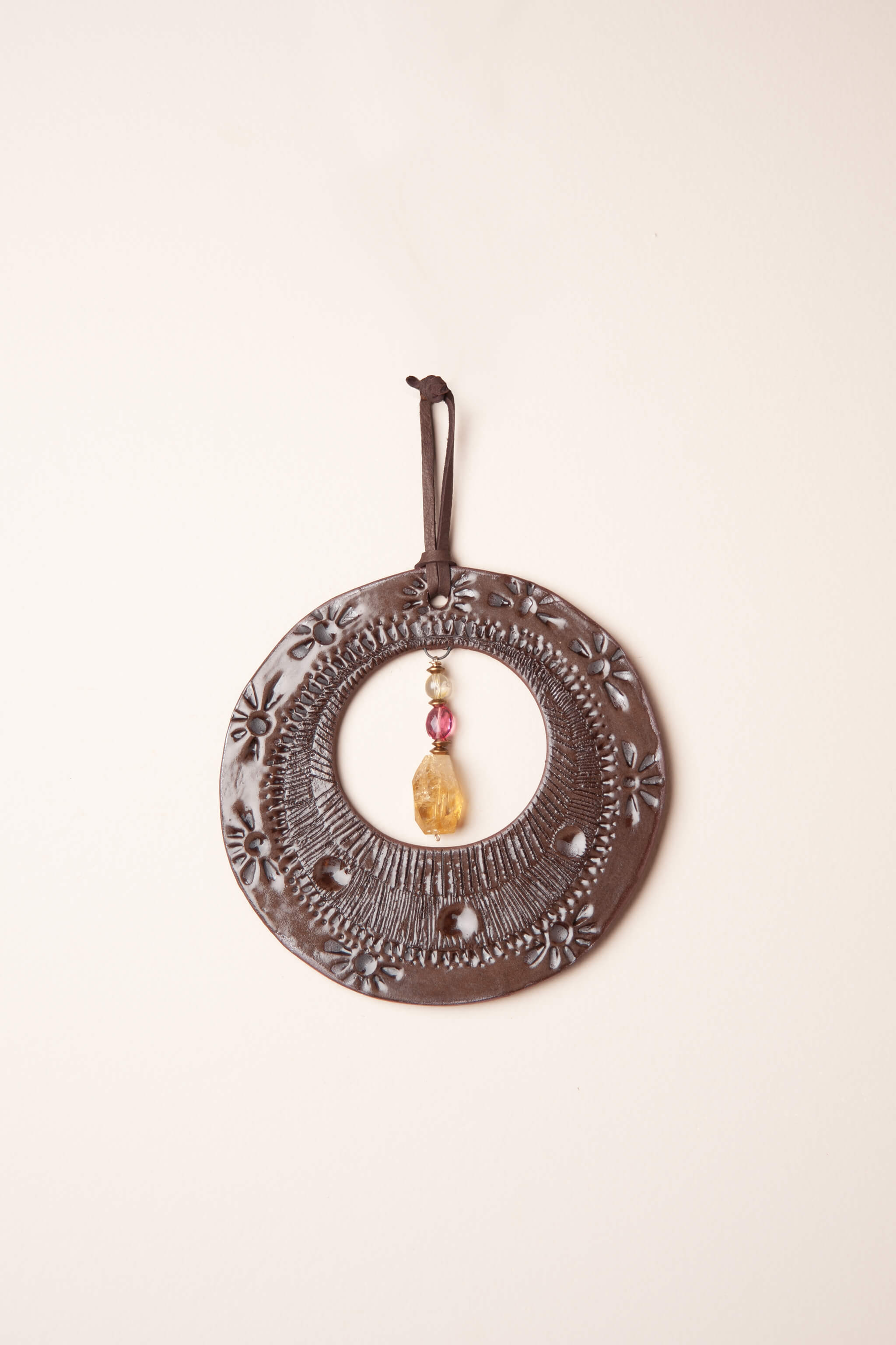 Small handmade southwest inspired ceramic circle wall hanging in chocolate brown with rubelite tourmaline and citrine, kiln fired by Jester Swink Santa Cruz Mountains — From the Fire FTF_0726