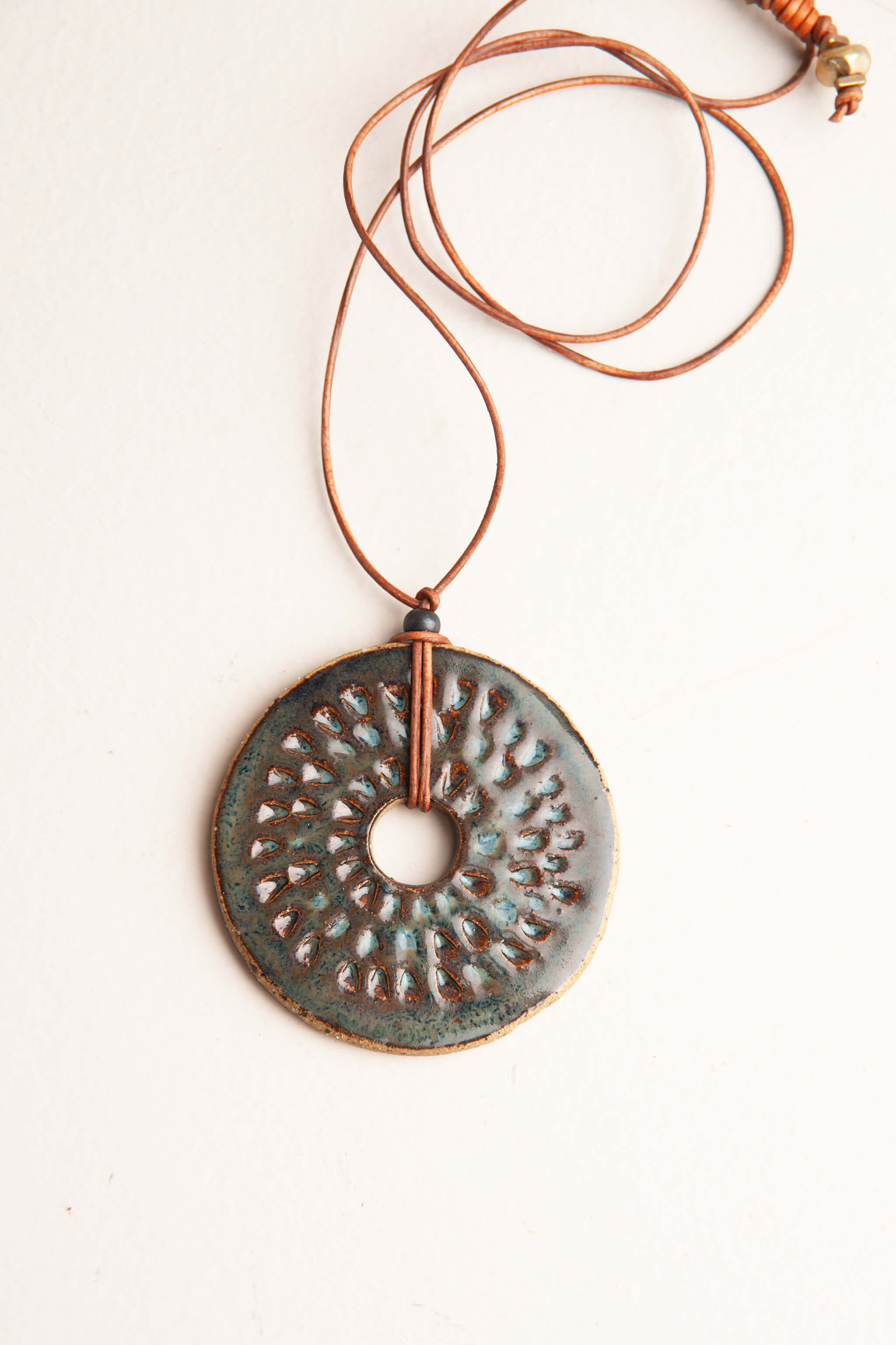 Handmade ceramic sunburst pendant necklace in aquamarine glaze on speckled buff clay with caramel Italian leather, kiln fired by Jester Swink Santa Cruz Mountains — From the Fire FTF_0726