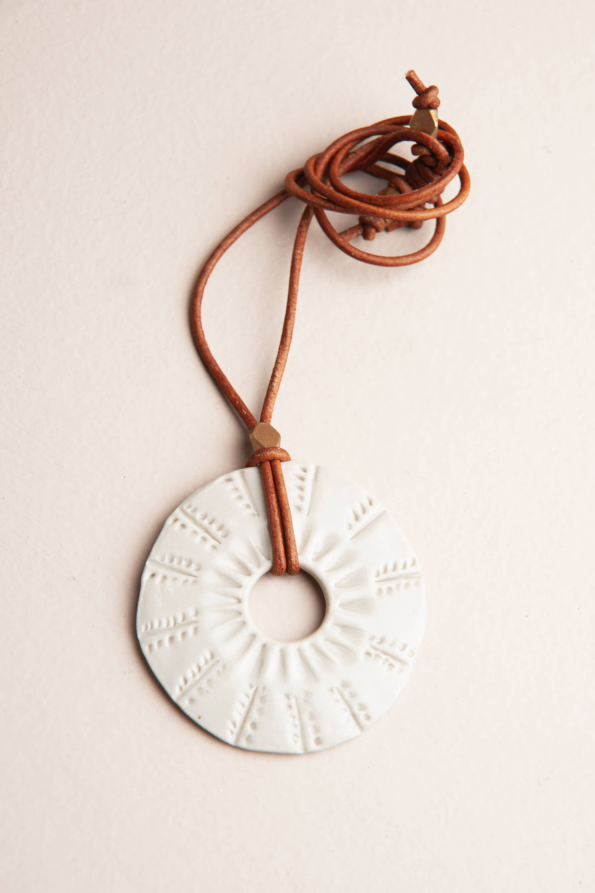 Handmade white porcelain ceramic sunburst pendant necklace on caramel Italian leather, kiln fired by Jester Swink Santa Cruz Mountains — From the Fire FTF_0726