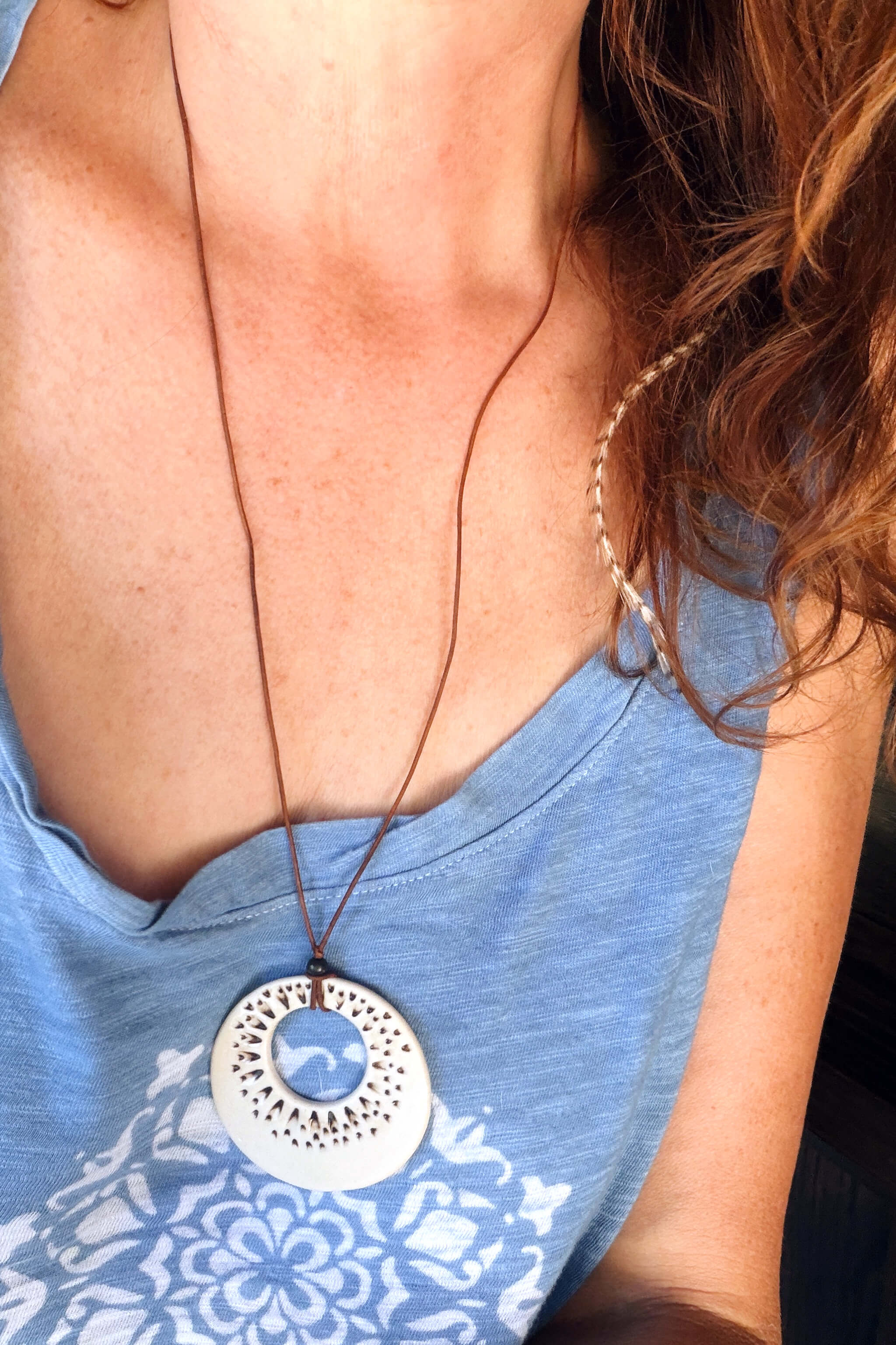 Handmade ivory ceramic sunburst ring pendant necklace worn at long boho length on dark Italian leather — From the Fire FTF_0726 by Jester Swink