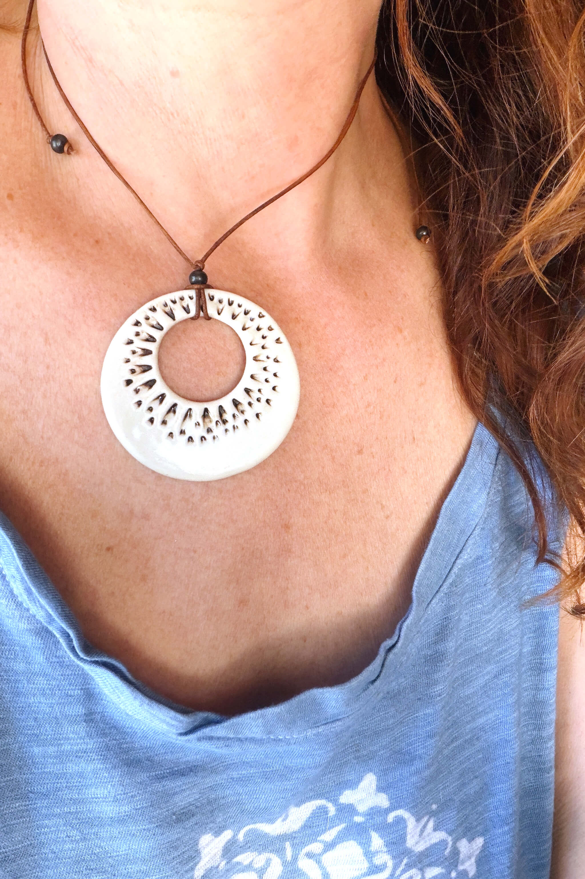 Handmade ivory ceramic sunburst ring pendant necklace worn at shorter length — modern ceramic jewelry From the Fire FTF_0726 by Jester Swink