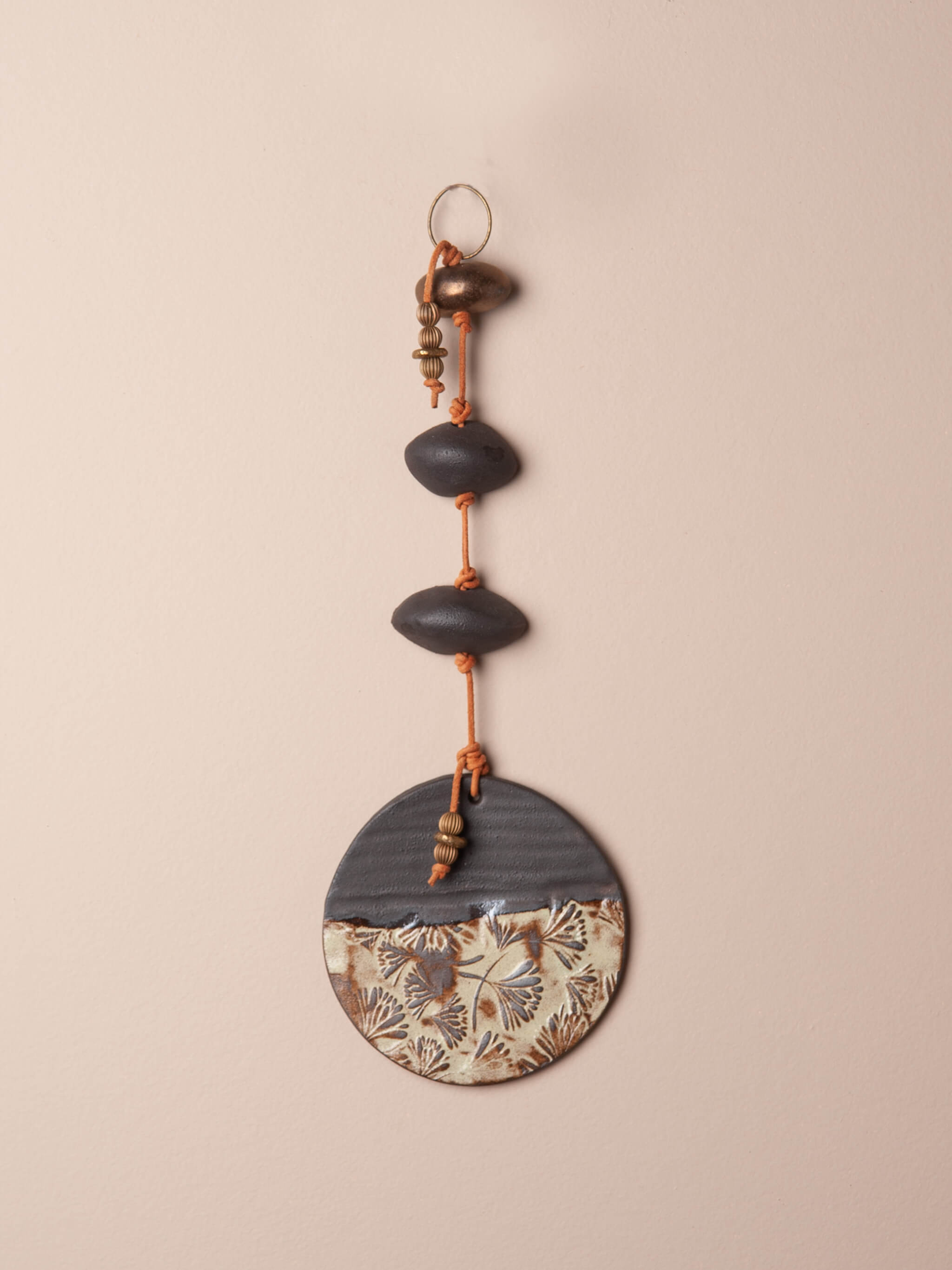 Handcrafted ceramic wall hanging with Japanese floral impression, sage glaze, handmade clay beads, brass ring and leather — Twilight Garden by Jester Swink