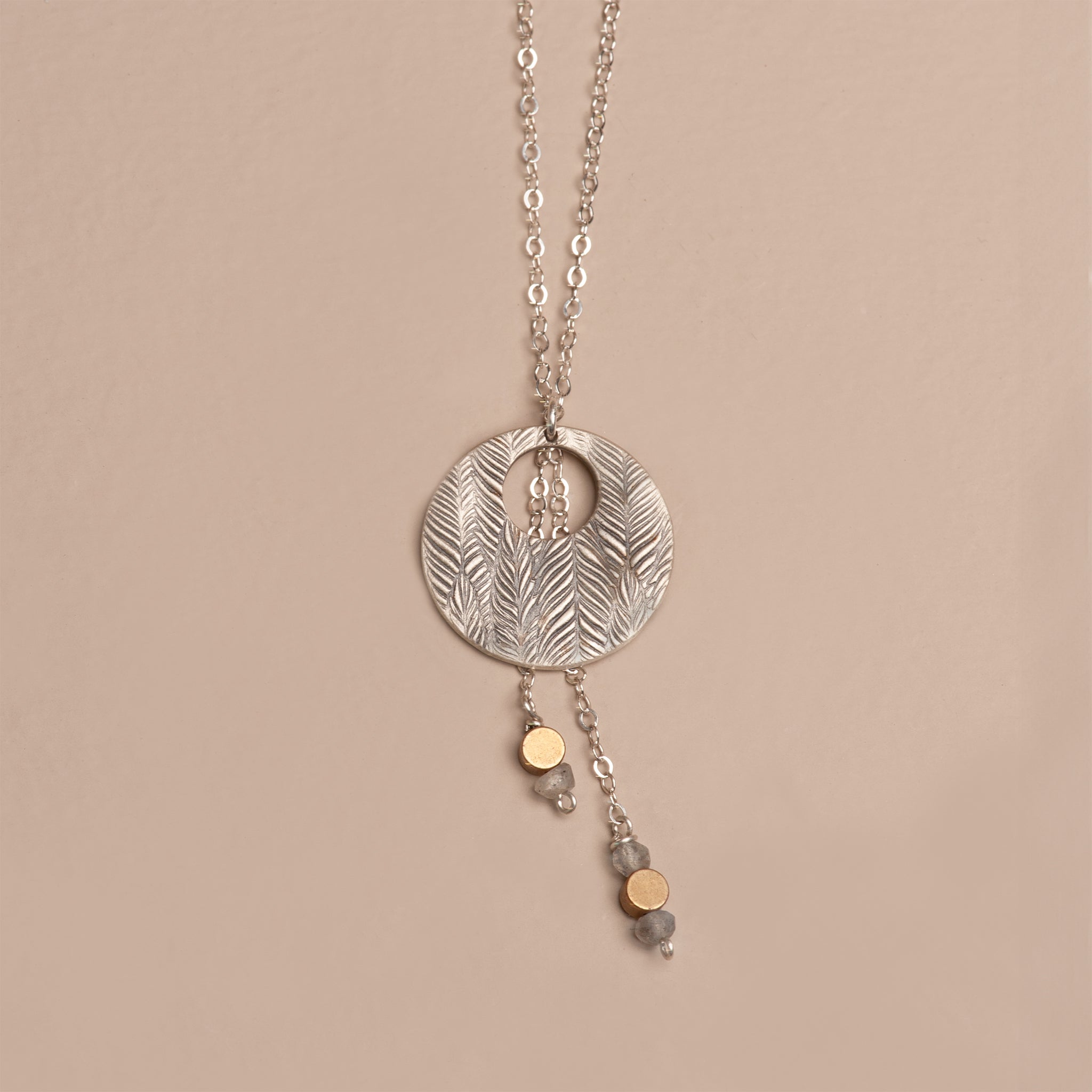 Oxidized sterling silver full moon pendant with a deep feather texture, cascading silver chains, and drops of gray labradorite and gold brass accents.