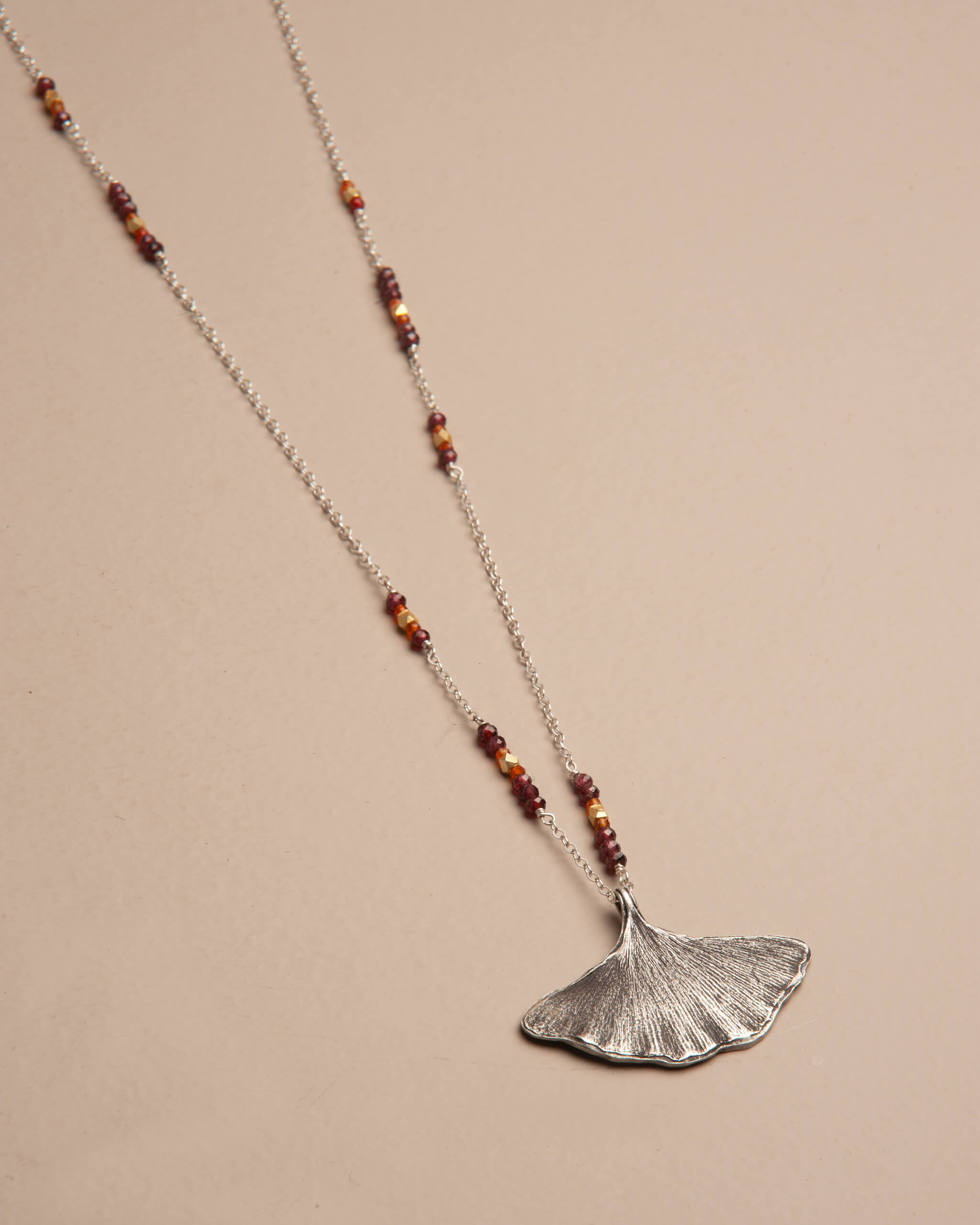 Asymmetrical sterling silver necklace with garnet, carnelian, and brass beads inspired by fall colors