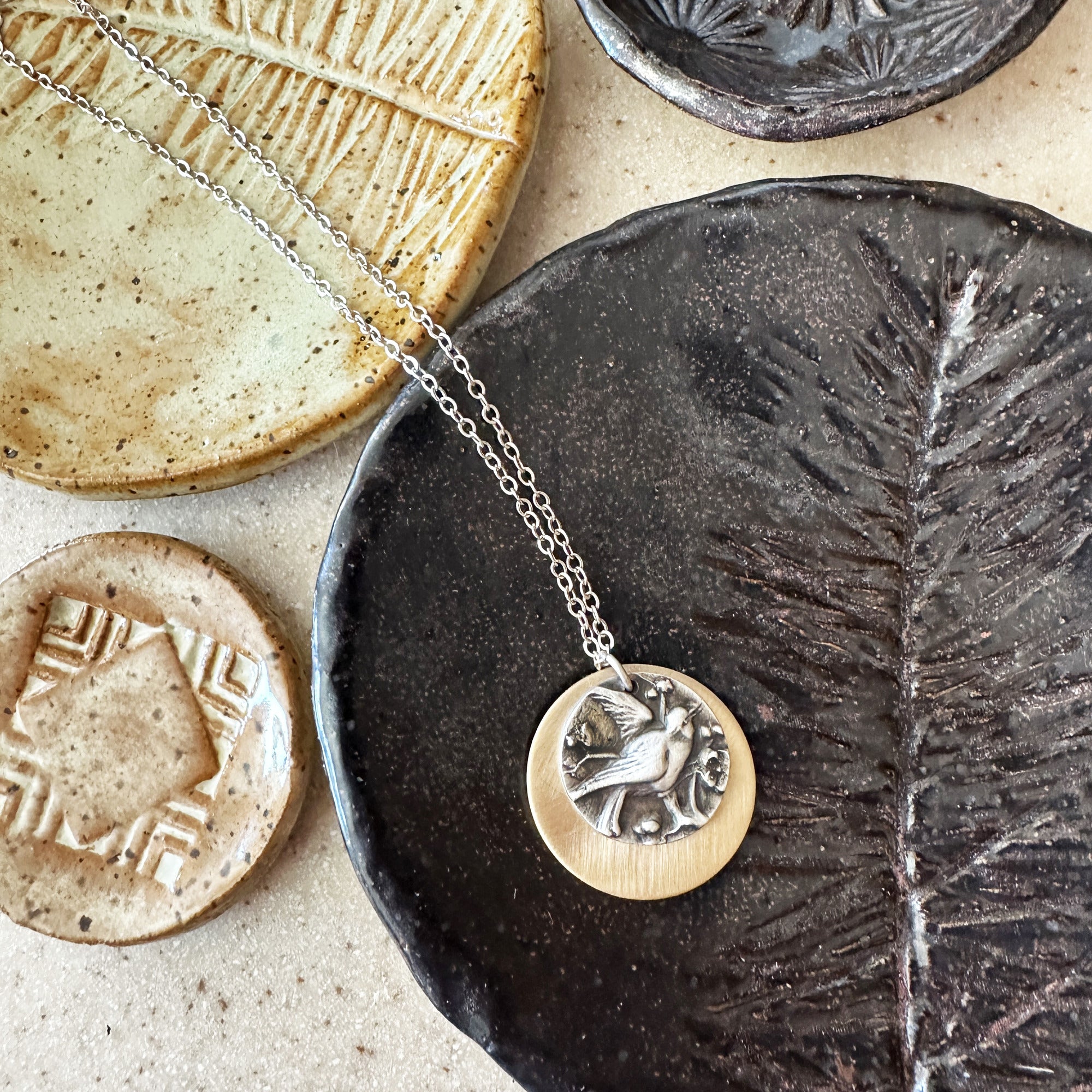 Birds of Flutter mixed metal necklace styled with handmade ceramic ring dishes, by Jester Swink