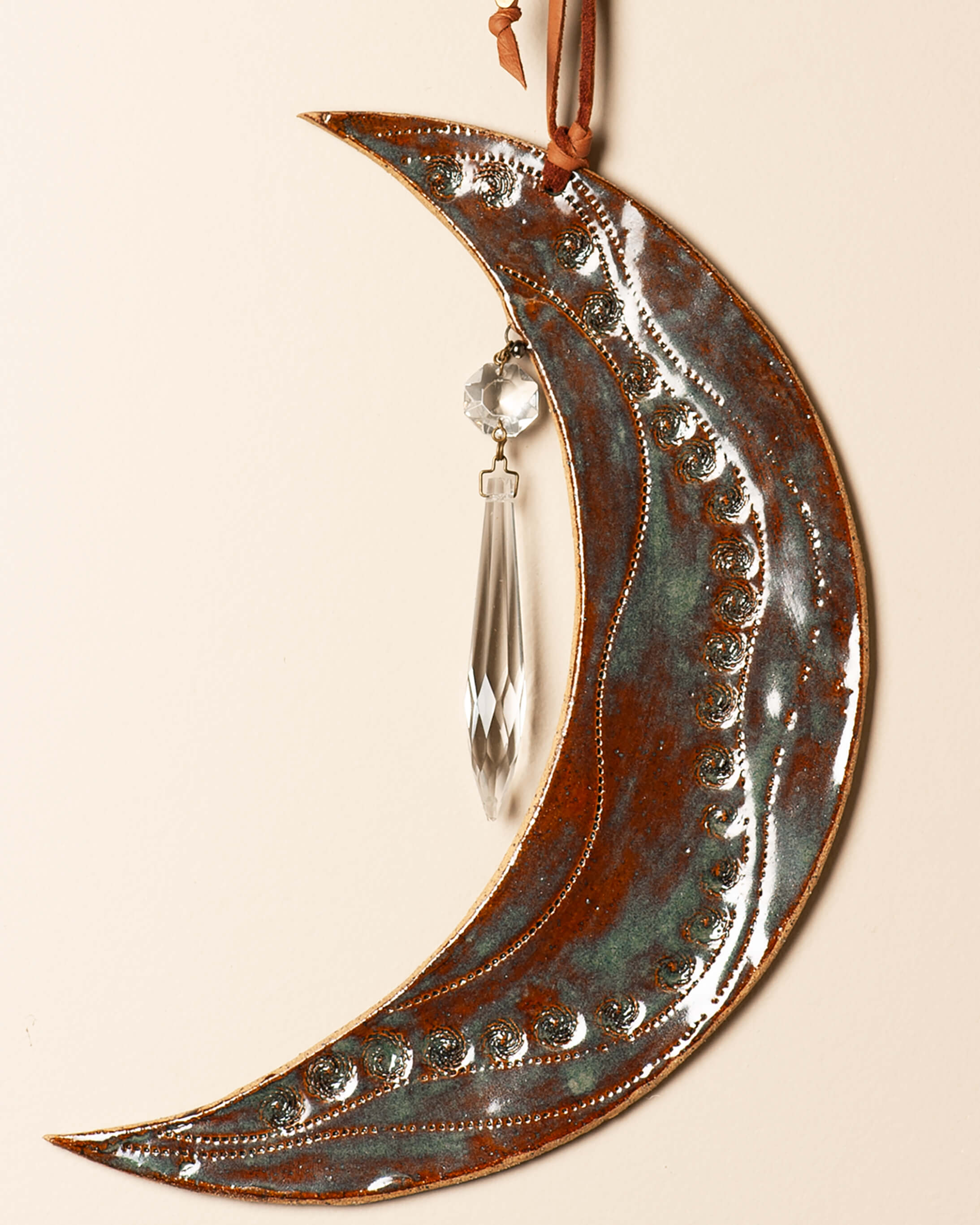 Close-up detail of protea seed pod impressions on handmade crescent moon wall art — copper patina, tiger's eye glaze, ceramic clay