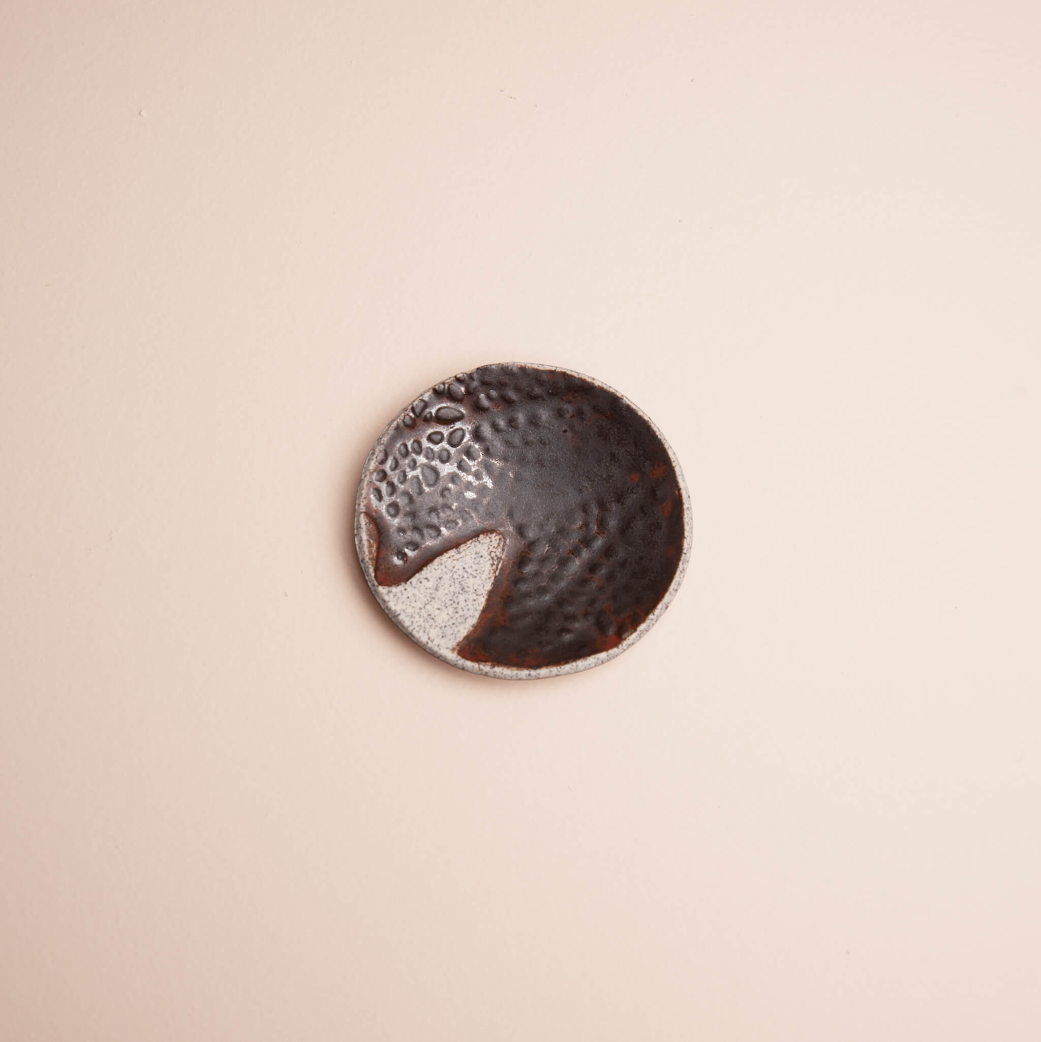 Overhead view of handmade ceramic Earth Seed Pod ring dish with deep brown glaze and raised seed pod texture on dragon fruit clay, by Jester Swink