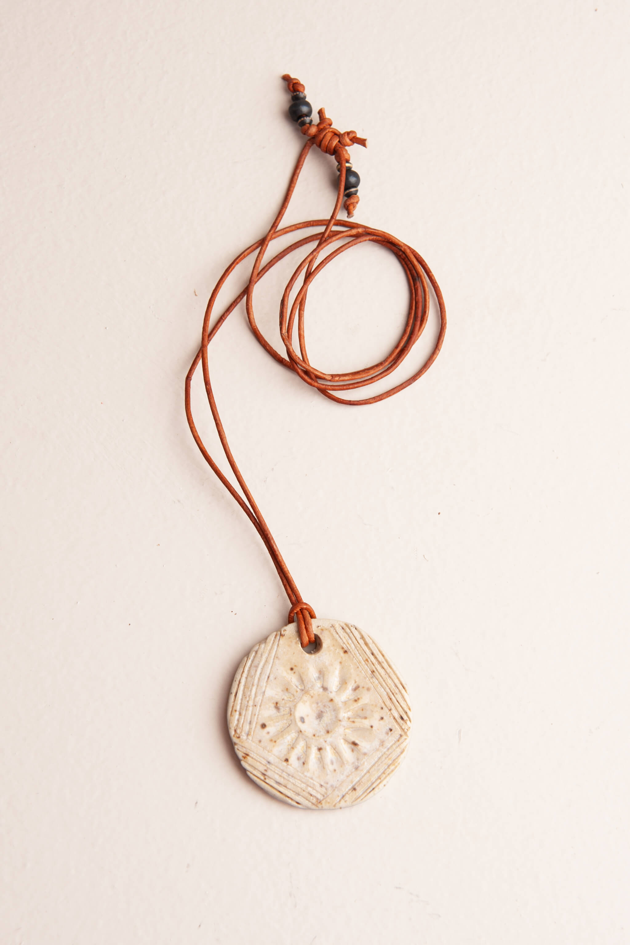 Handmade speckled white ceramic faceted sunburst pendant necklace on caramel Italian leather, kiln fired by Jester Swink Santa Cruz Mountains — From the Fire FTF_0726