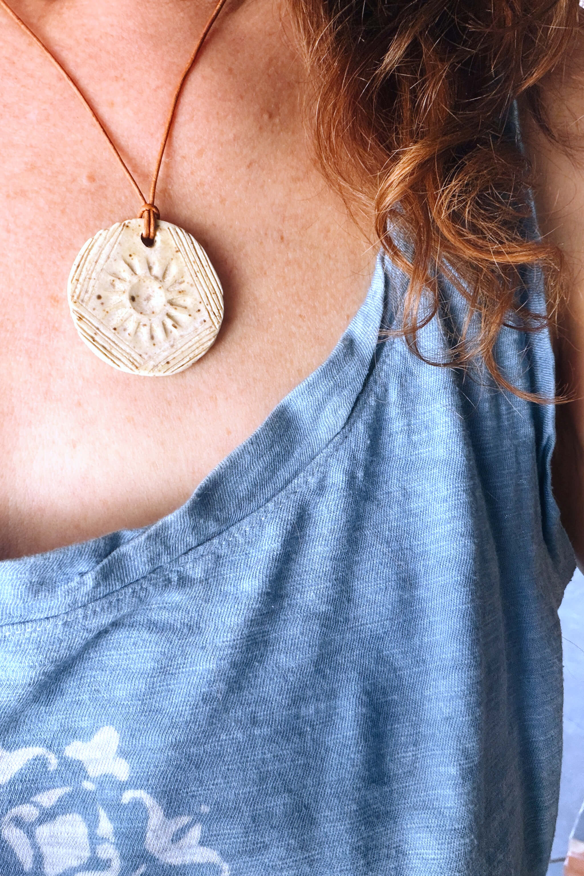 Handmade speckled white ceramic sunburst pendant necklace worn at shorter length — everyday ceramic jewelry From the Fire FTF_0726 by Jester Swink