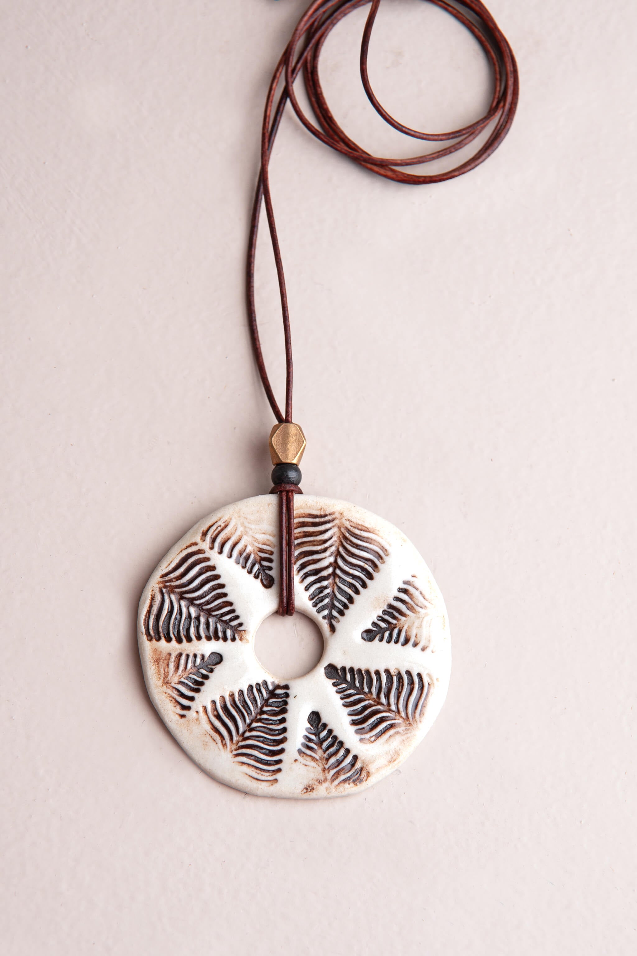 Handmade white porcelain fern sunburst ceramic pendant necklace with mocha underglaze on dark brown Italian leather, kiln fired by Jester Swink Santa Cruz Mountains — From the Fire FTF_0726