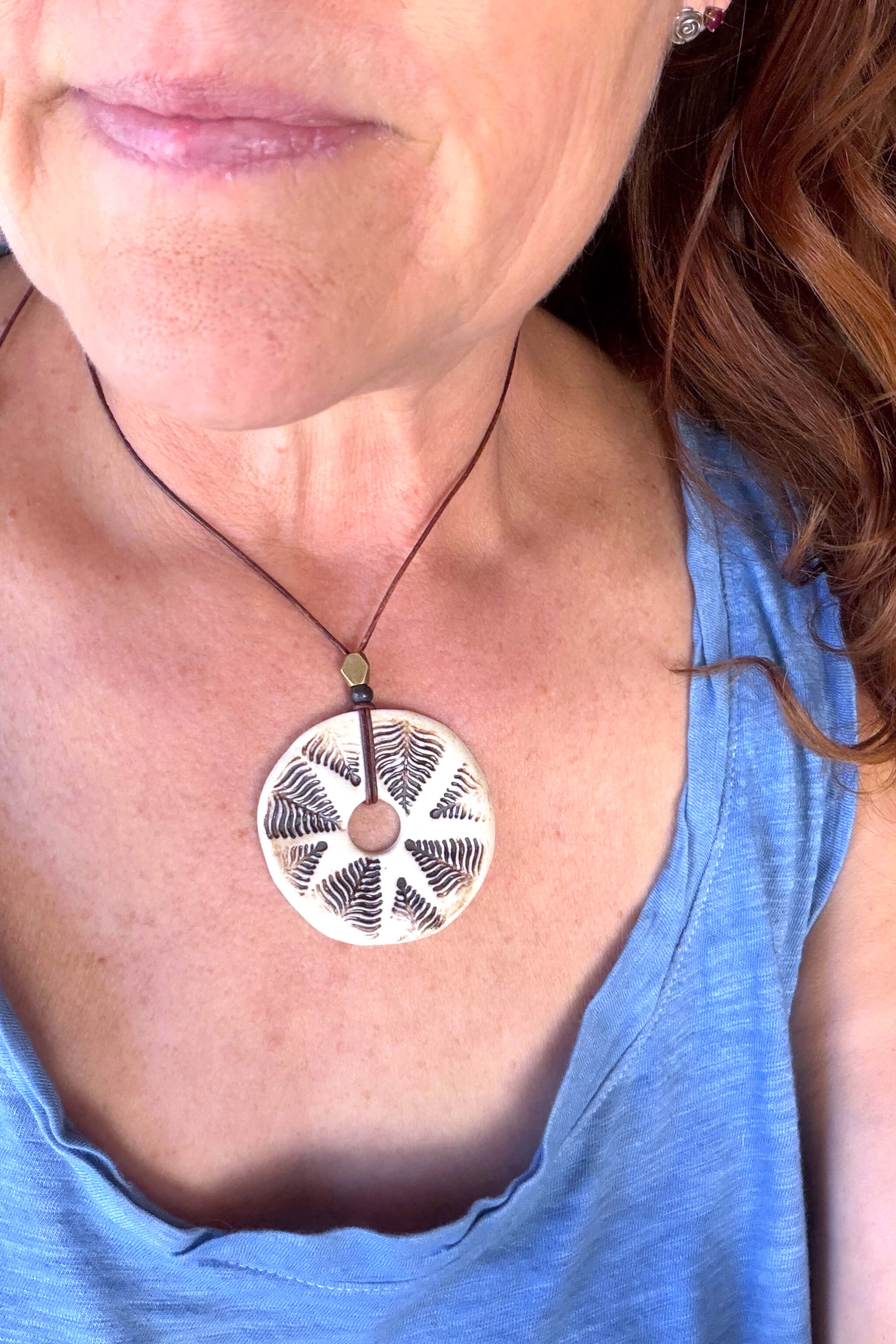 Handmade white and mocha fern sunburst ceramic pendant necklace worn at shorter length — nature inspired ceramic jewelry From the Fire FTF_0726 by Jester Swink