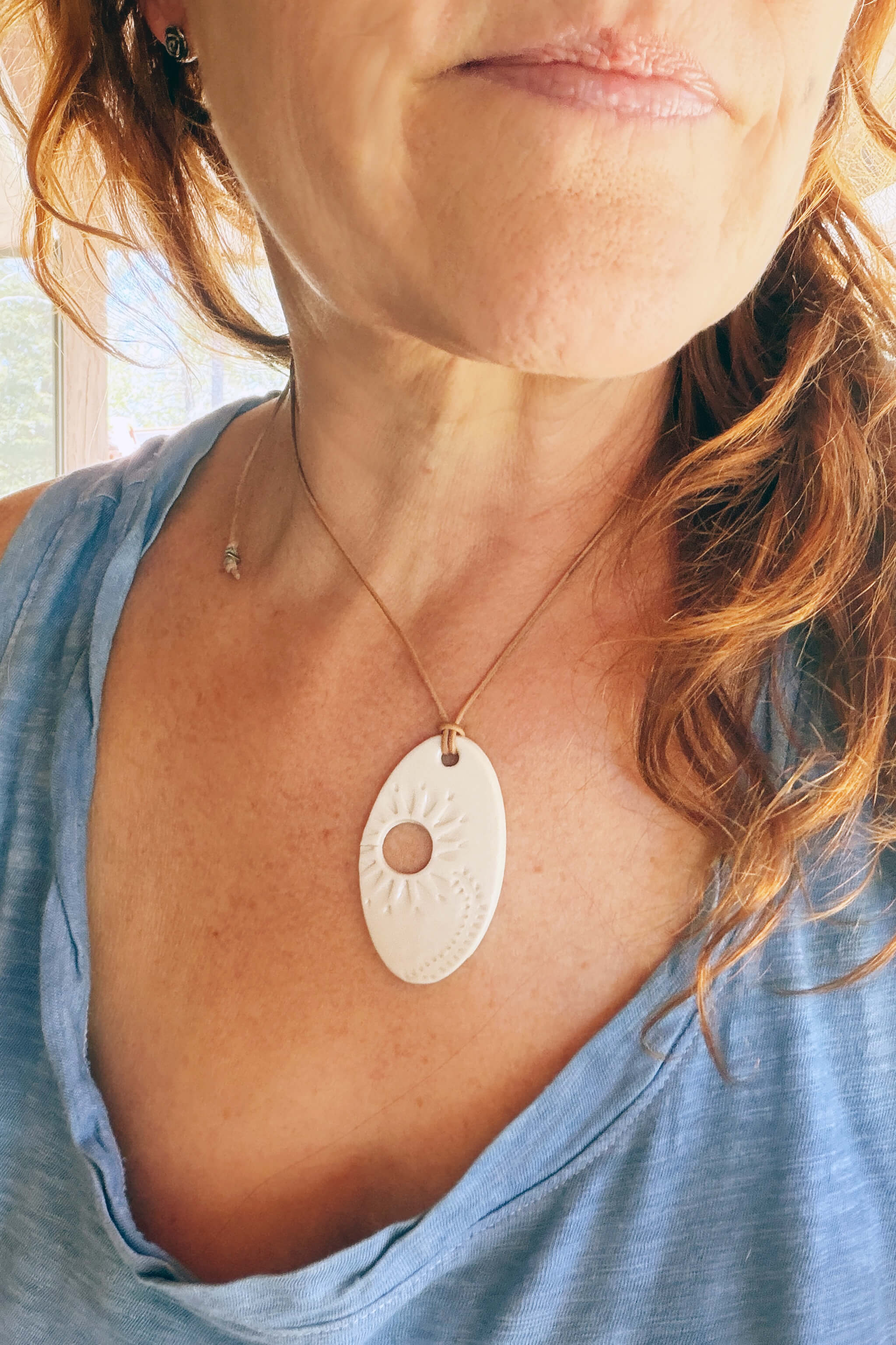 Handmade white porcelain floral ceramic pendant necklace worn at shorter length — From the Fire FTF_0726 by Jester Swink