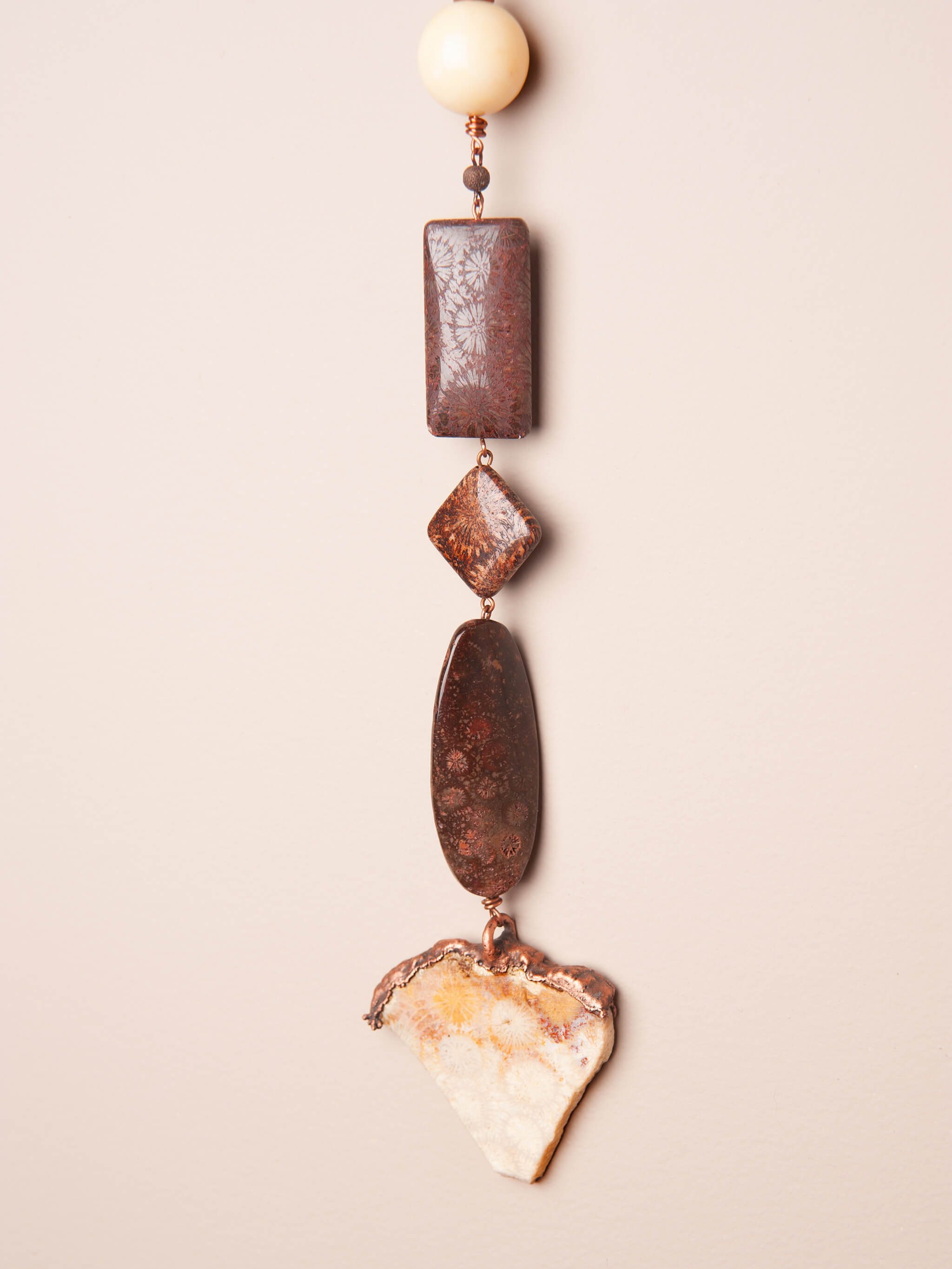 Close-up of fossilized coral agate pendant electroformed in copper — one of a kind wall hanging and wind spinner by Jester Swink Santa Cruz Mountains