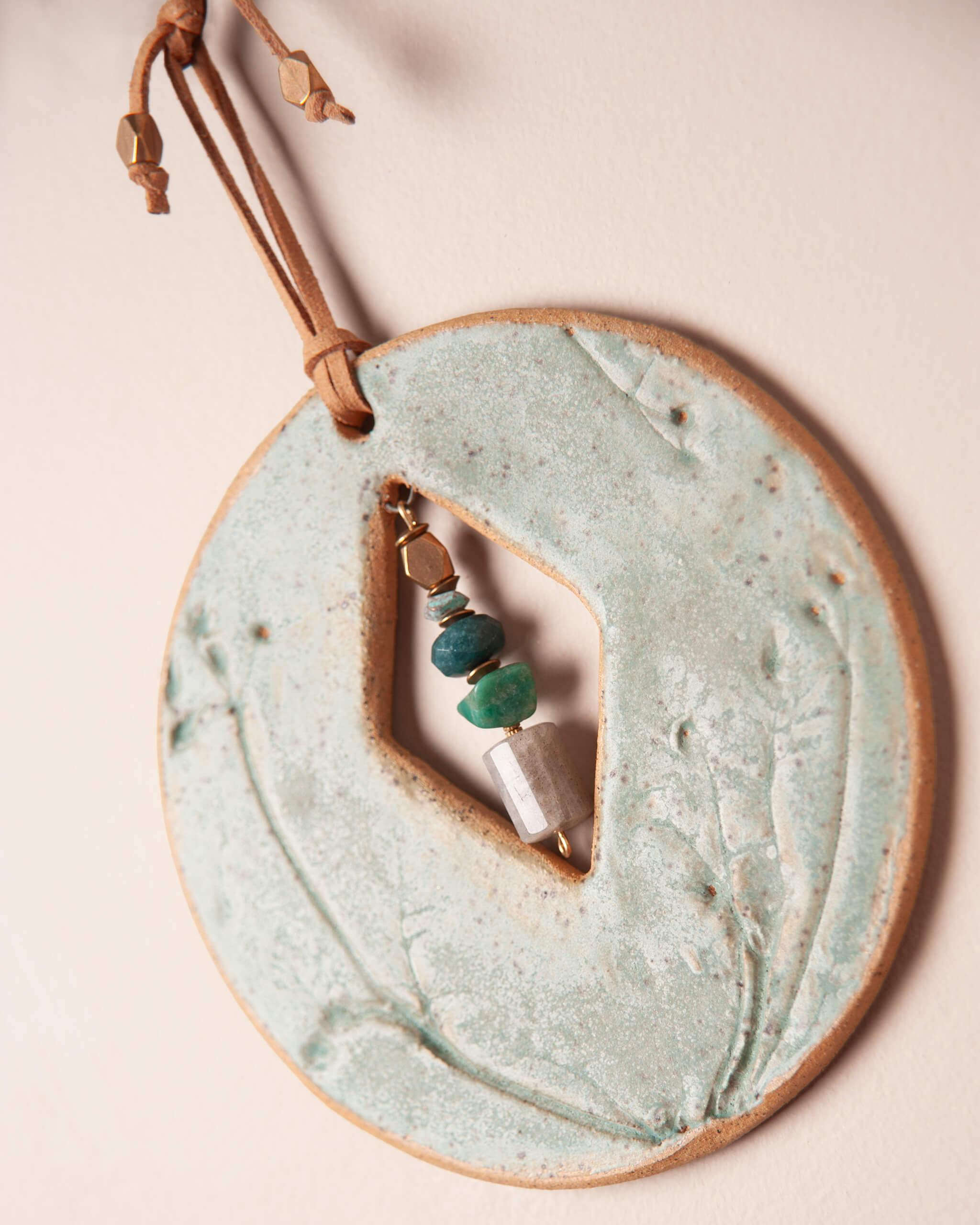 Close up of diamond geometric center opening on seafoam glazed sandy river rock ceramic clay with wildflower impression on Cairn Diamond Moon