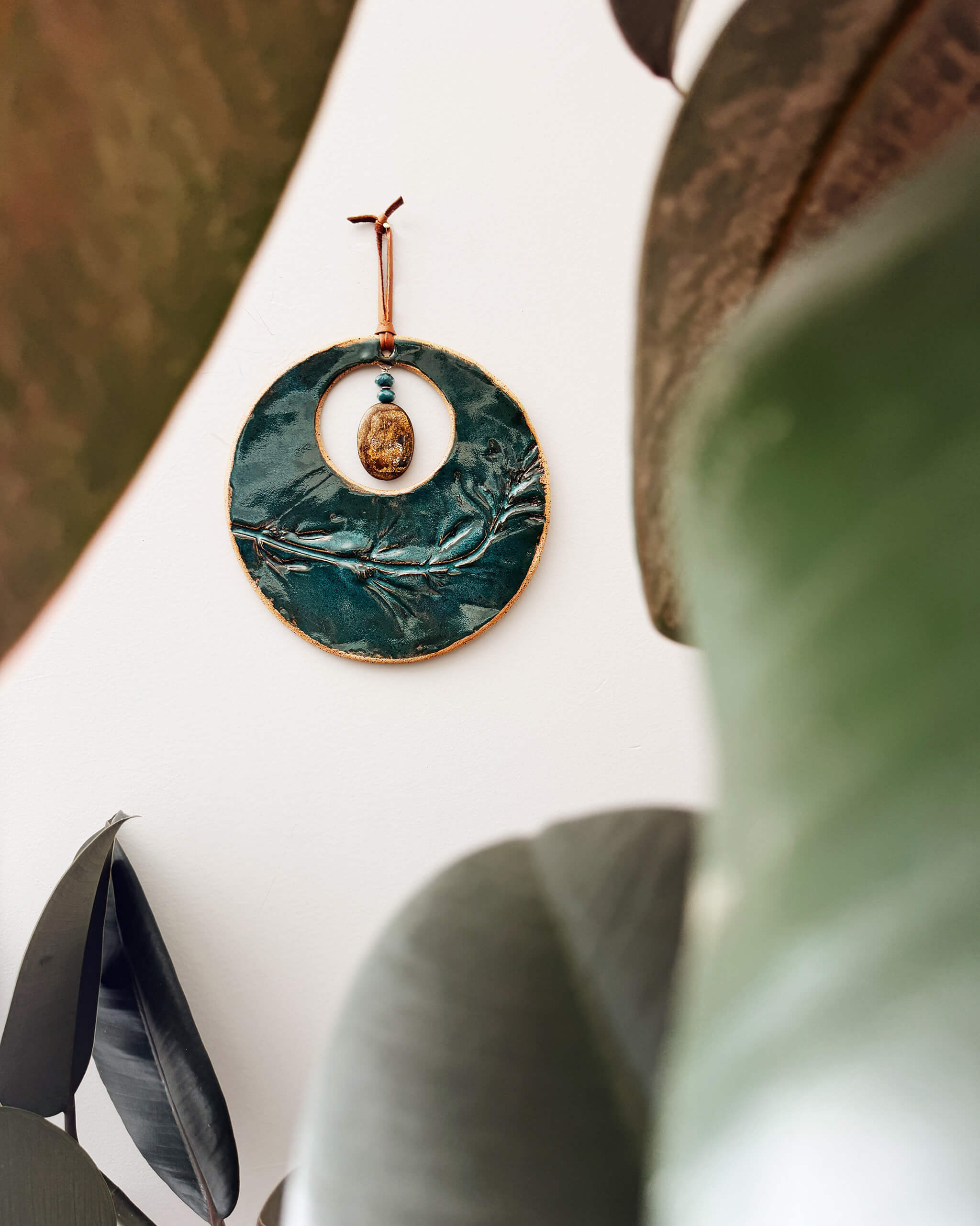 Emerald Wildflower Moon handmade ceramic wall hanging in home setting