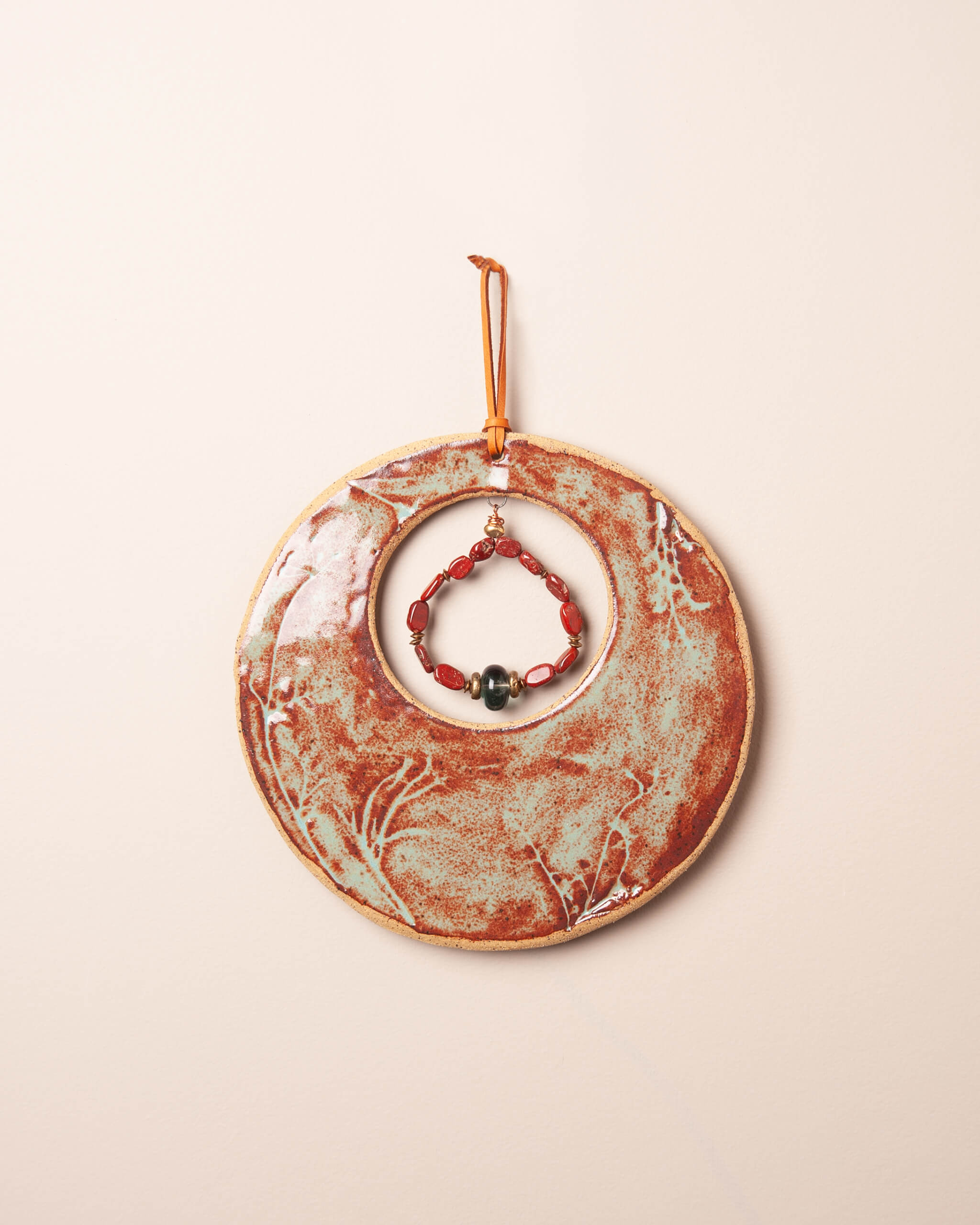 Meadow Moon handmade ceramic wall hanging with wildflower impression, rusty terracotta and sage glaze, jasper and fluorite pendant, Santa Cruz Mountains
