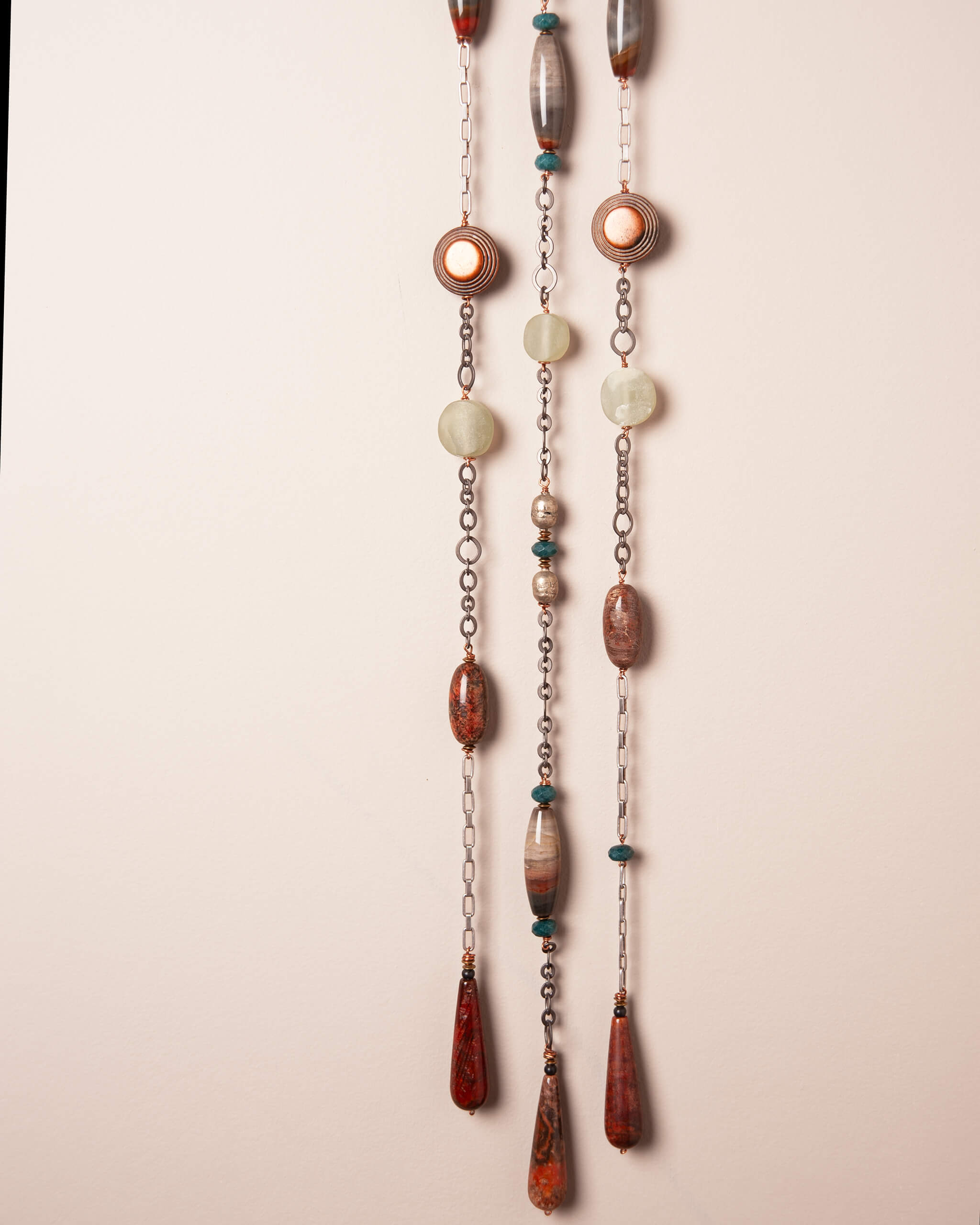 Close up of fossilized coral agate drops at the bottom of Redwood Rain with copper wire wrap and bronze metal accents